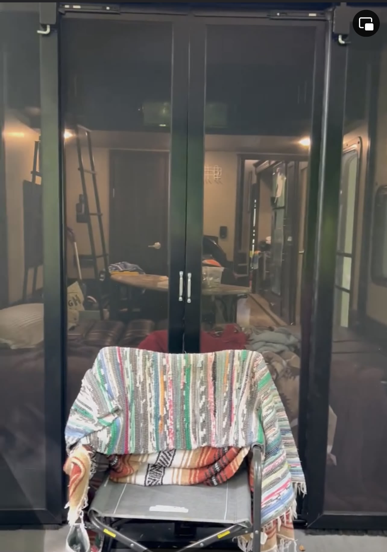 RV rental: Inside a toy hauler through a screen, showing a ladder, table, and a cot with blankets.. Forest River Xlr Thunrderbolt 2017