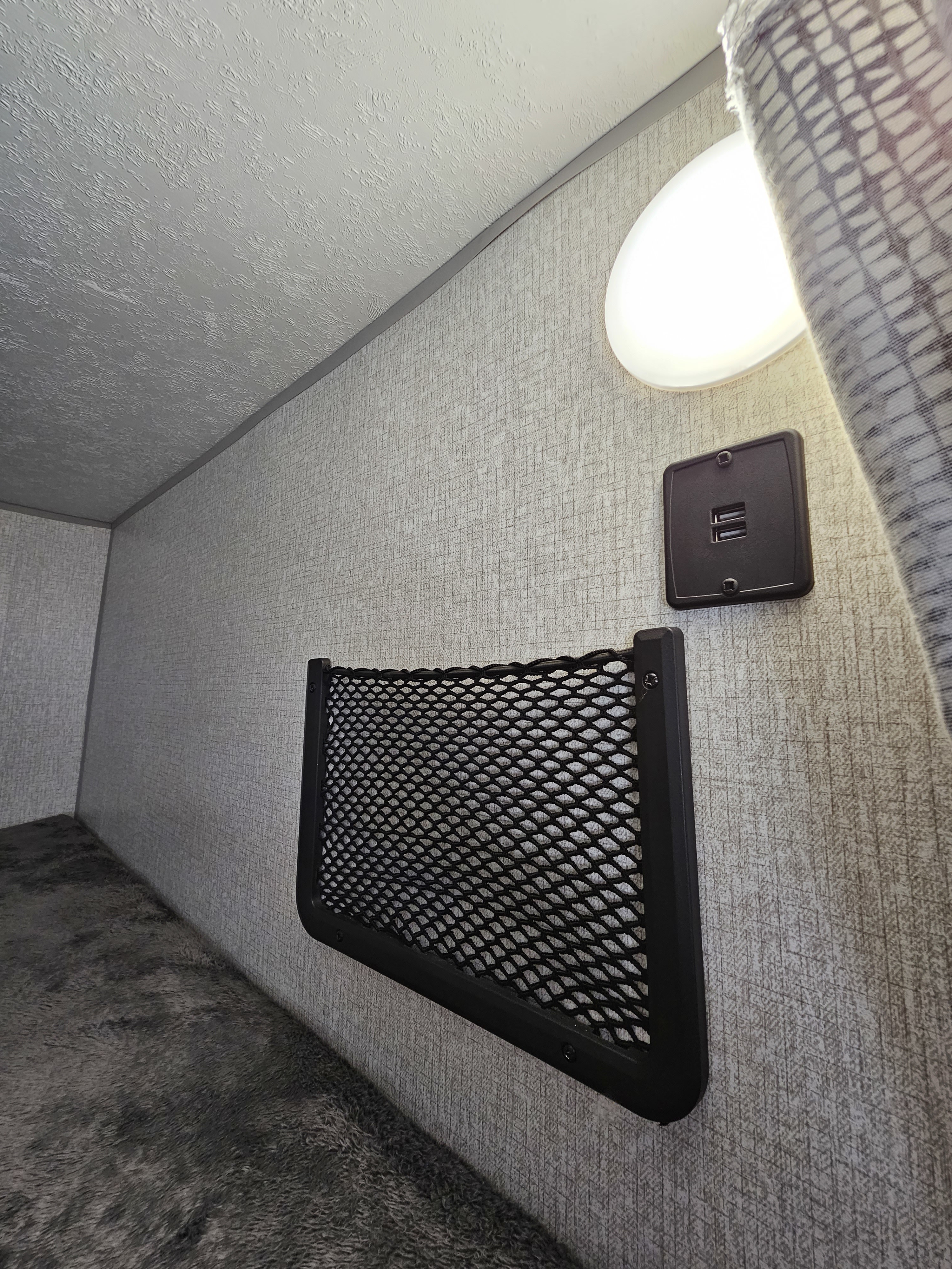 RV rental bunk bed with an illuminated light, convenient dual USB charging port, and mesh storage net.. Venture Stratus 2022