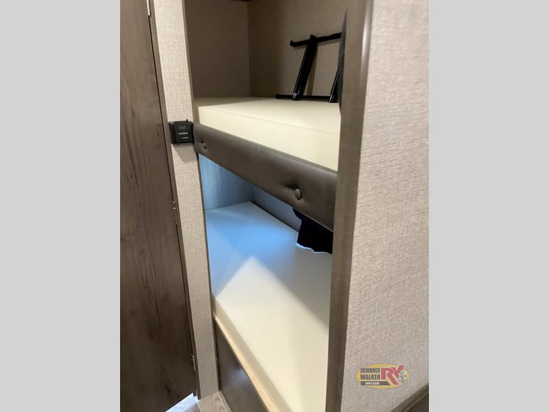 This RV rental interior showcases cozy bunk beds with white mattresses, ideal for families. A small control panel is visible.. Jayco Jay Flight SLX Baja Edition 2021