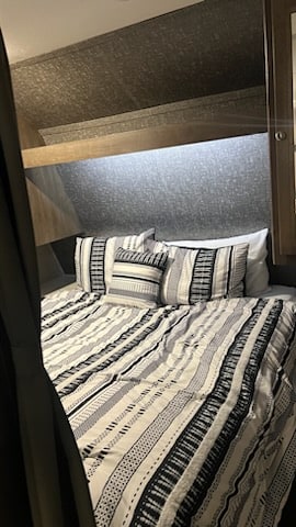 Comfortable Queen-size bed with storage cabinet space on either side. . Dutchmen Coleman Lantern LT 2019