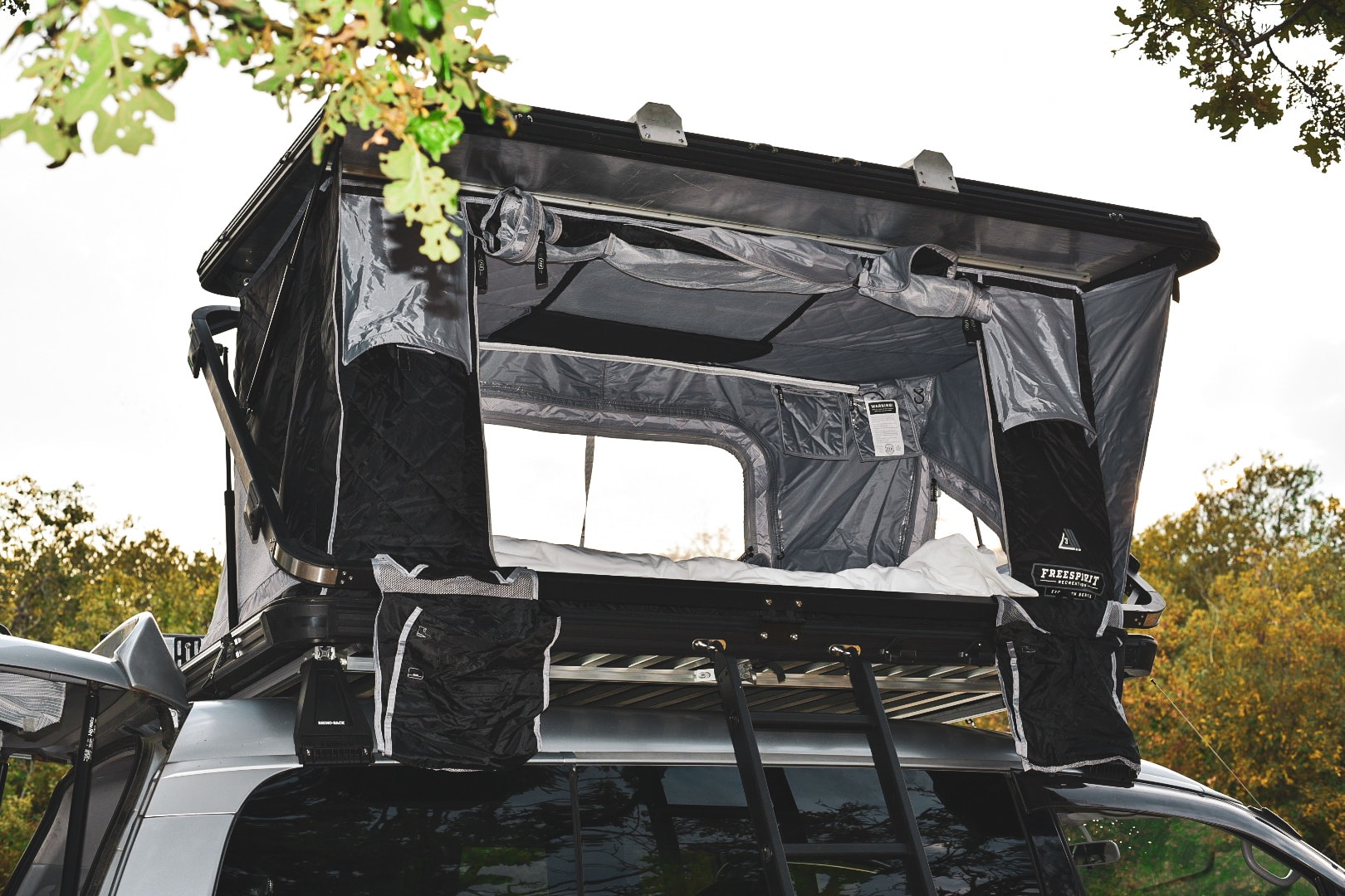 This RV rental features a rooftop tent, open to reveal a bed. Ready for camping adventures.. Mitsubishi Delica 2005