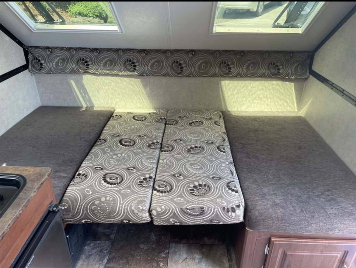 Inside an RV rental: features include convertible sleeping areas, a mini-kitchen, and overhead skylights for natural light.. Forest River Rockwood Premier 2015