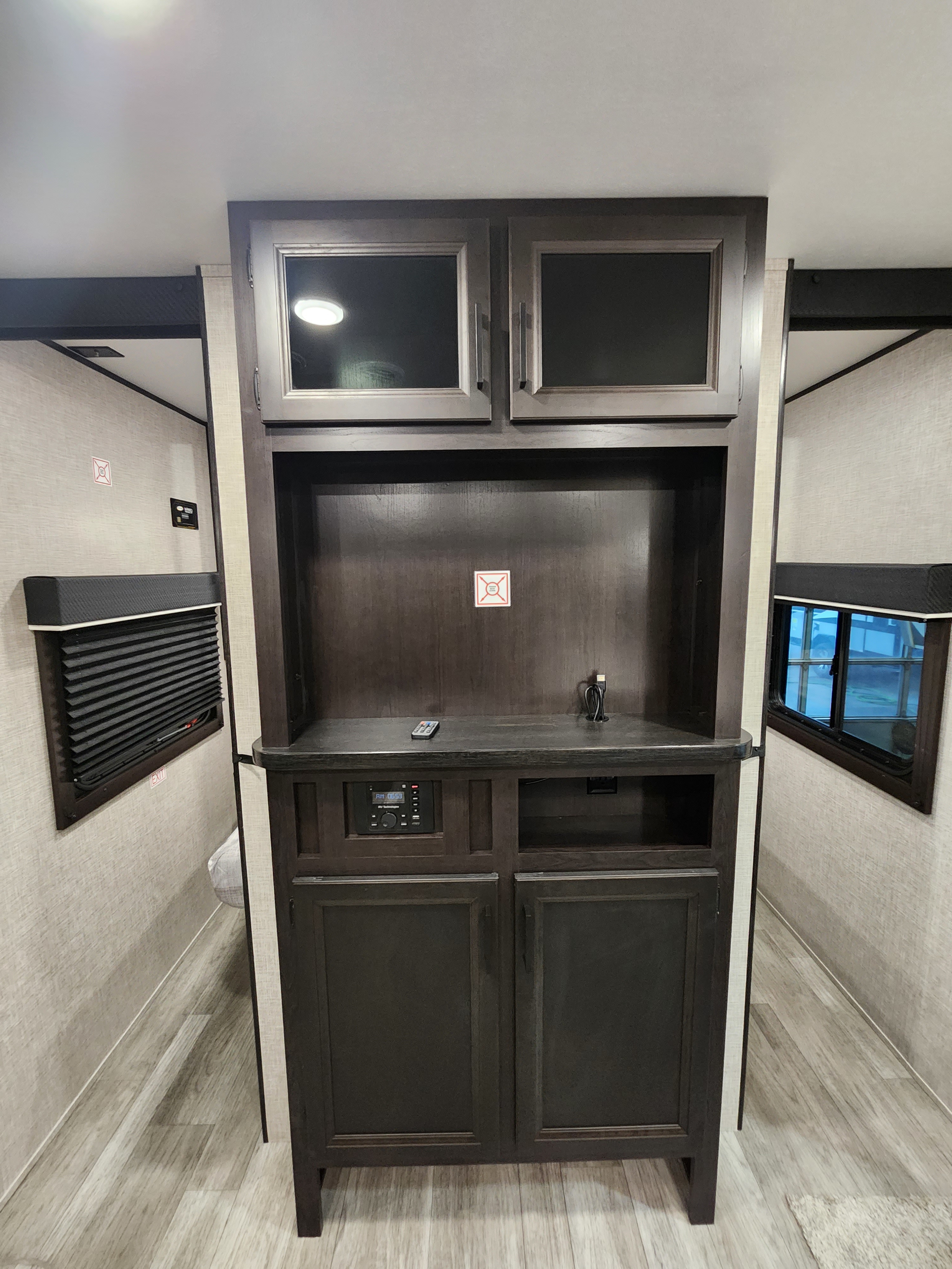 RV rental interior: modern entertainment center with stereo, storage cabinets, and large windows on both sides.. Jayco Jay Flight 2023