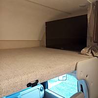 This RV rental features a cozy cab-over bunk bed with a large flat-screen TV, offering comfort for your journey's rest.. Thor Freedom Elite 2019