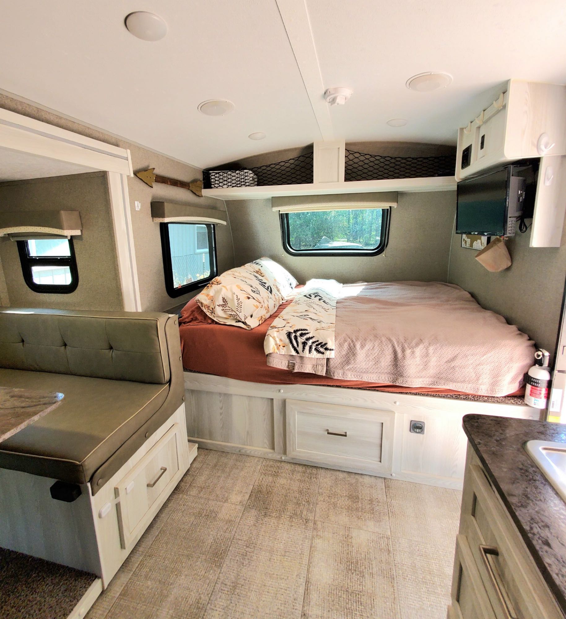 Cozy RV rental interior showcasing a compact bedroom, dinette, and kitchen corner, perfect for comfortable travel.. Forest River Rockwood Geo Pro 2020