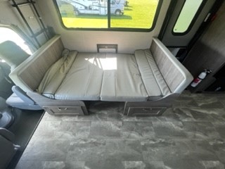 Spacious RV rental interior: U-shaped dinette converts to a comfortable bed with under-storage, brightened by large window.. Gulf Stream Conquest 63111 2024