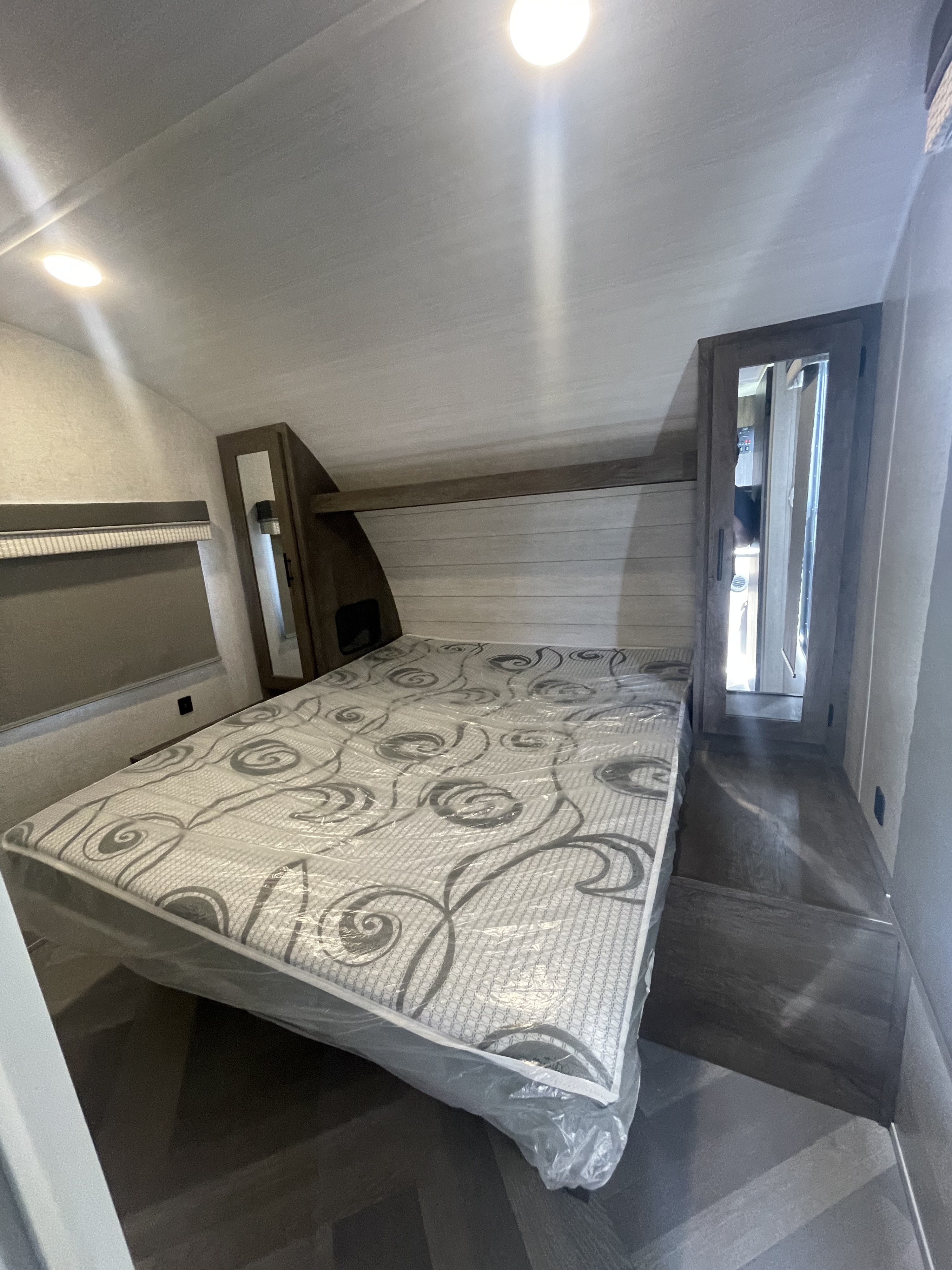 New RV rental bedroom featuring a wrapped mattress & compact built-in storage. Ideal for travel.. Forest River Wildwood X-Lite 2021