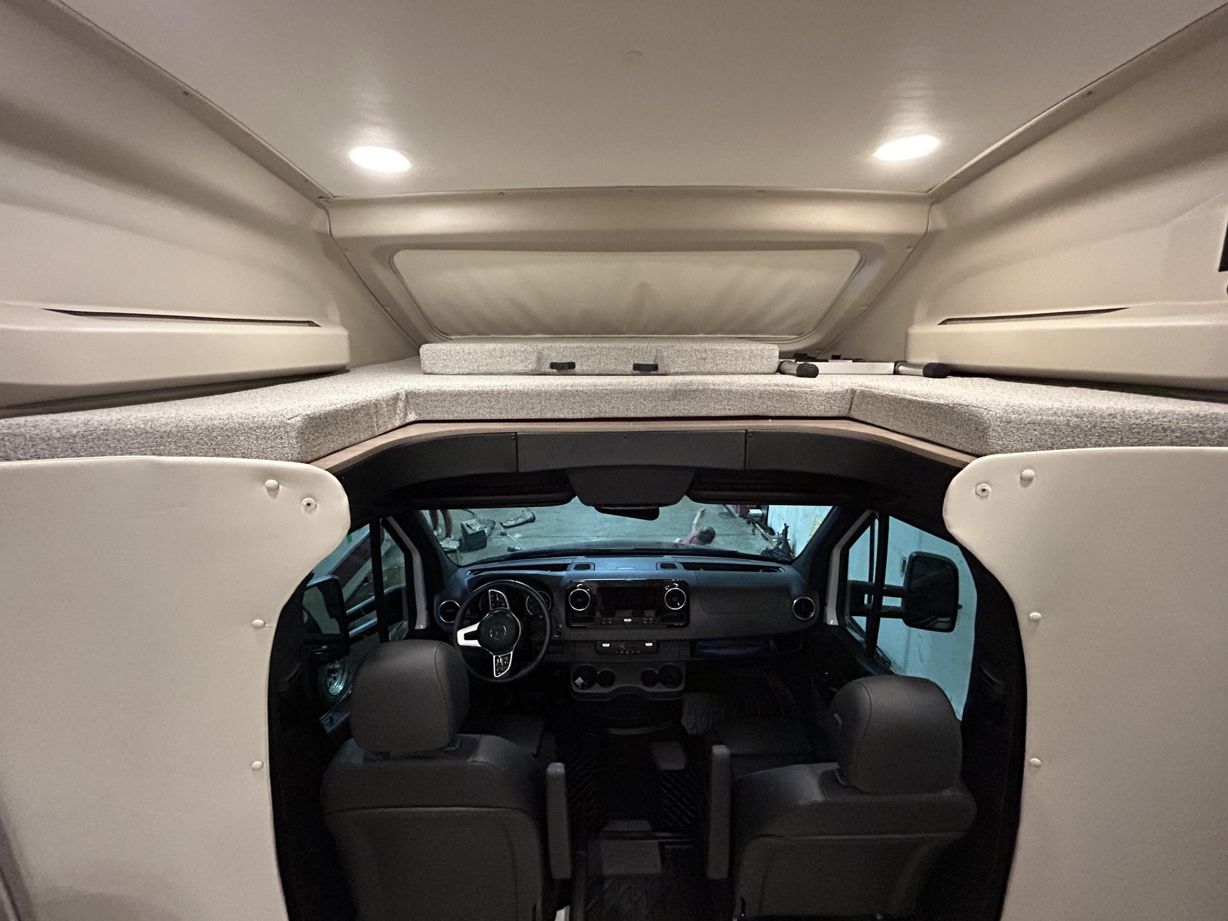 Explore this clean RV rental interior, featuring a cozy over-cab sleeping bunk and the well-equipped driver's cockpit.. Jayco Melbourne 2022