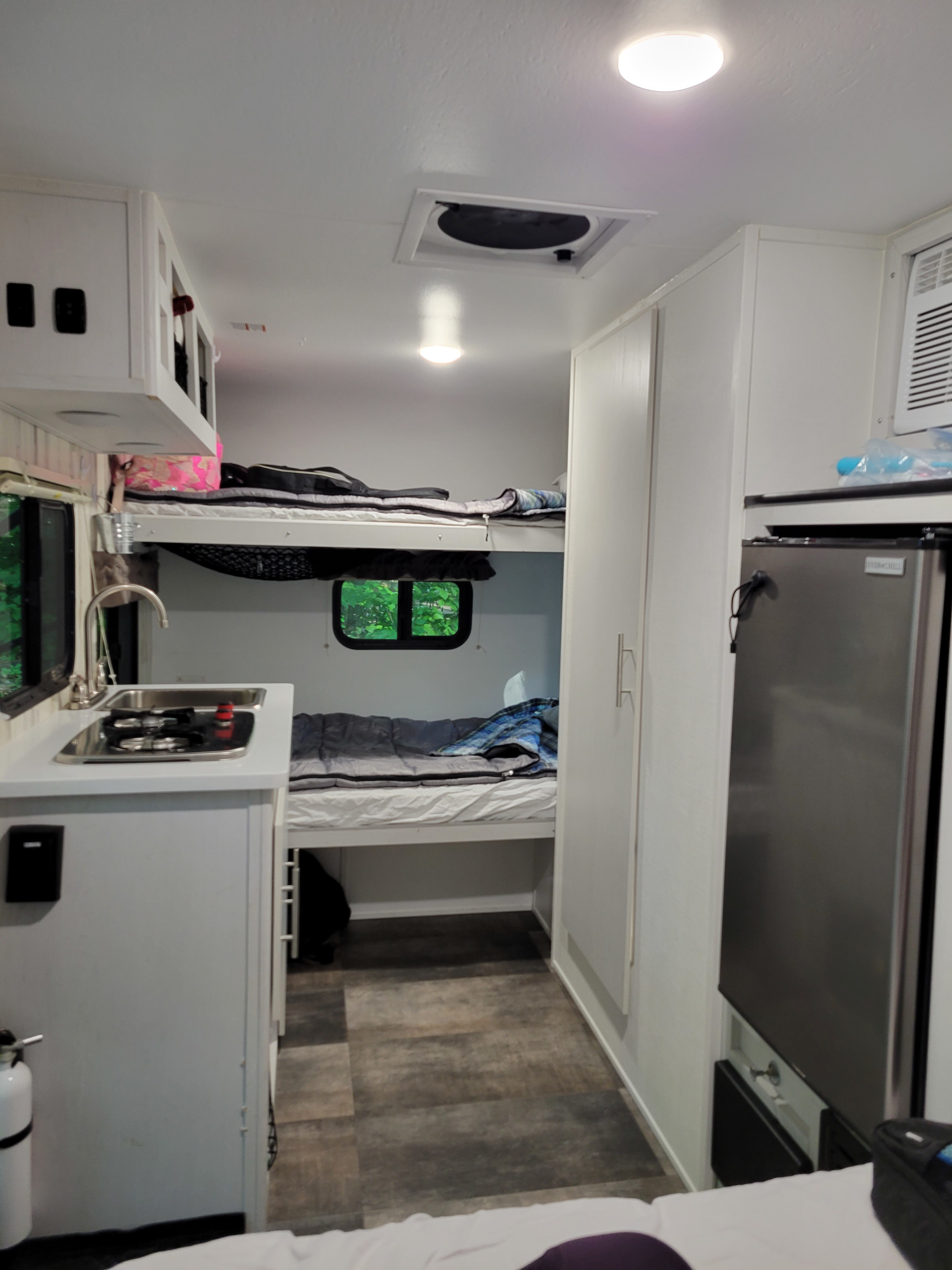 RV rental: Compact kitchen, bunk beds, and fridge visible in this modern, bright interior.. Travel Lite Rove Lite 2022