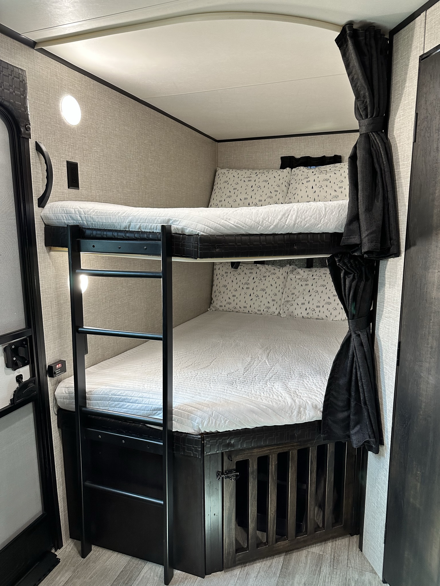 Cozy RV rental bunk beds with a built-in dog kennel and ladder, ideal for family travel and camping.. Jayco Jay Flight 2022