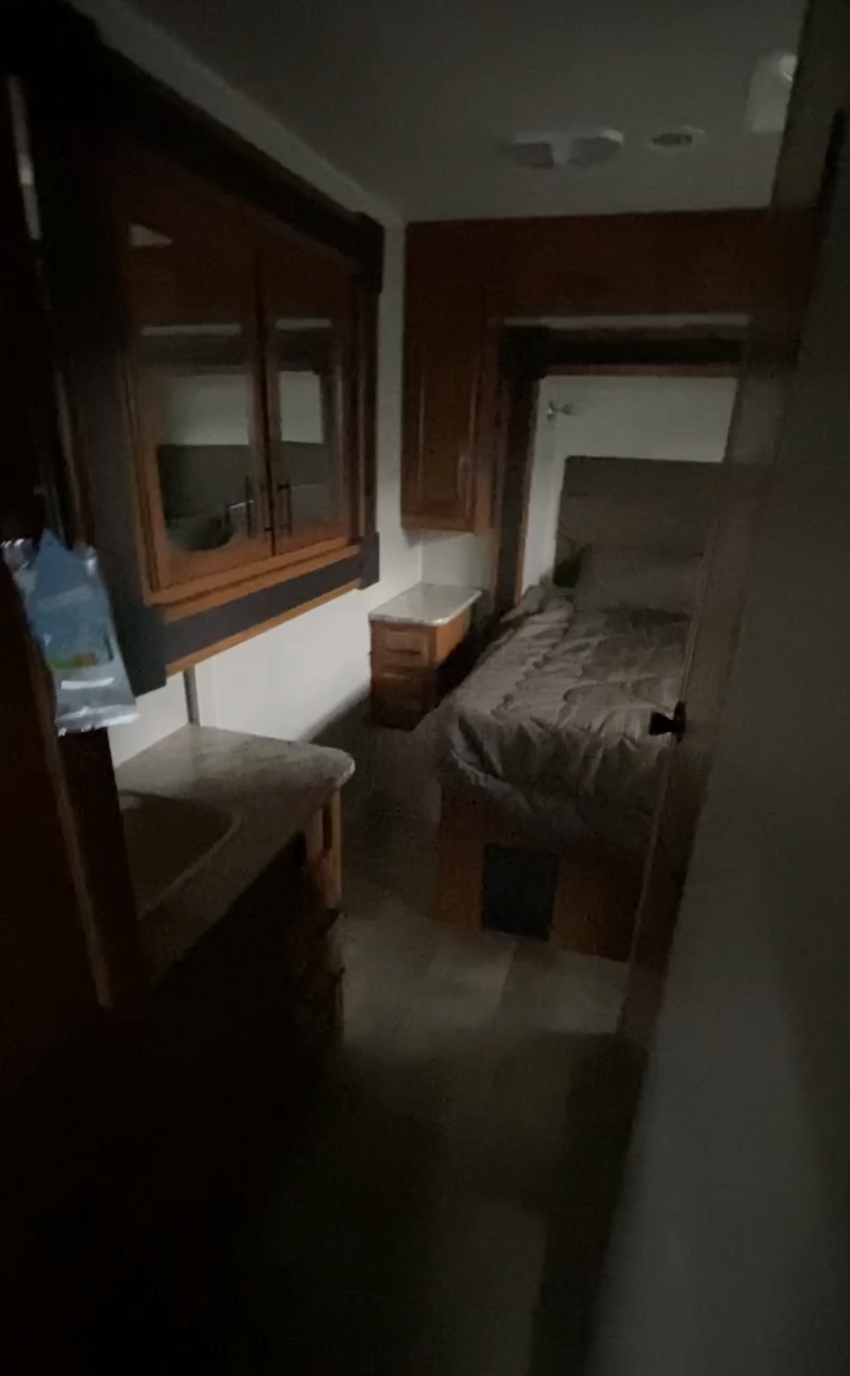 Compact RV rental interior featuring a small bed, nightstand, and cabinets for a cozy travel stay.. Jayco Redhawk 2017