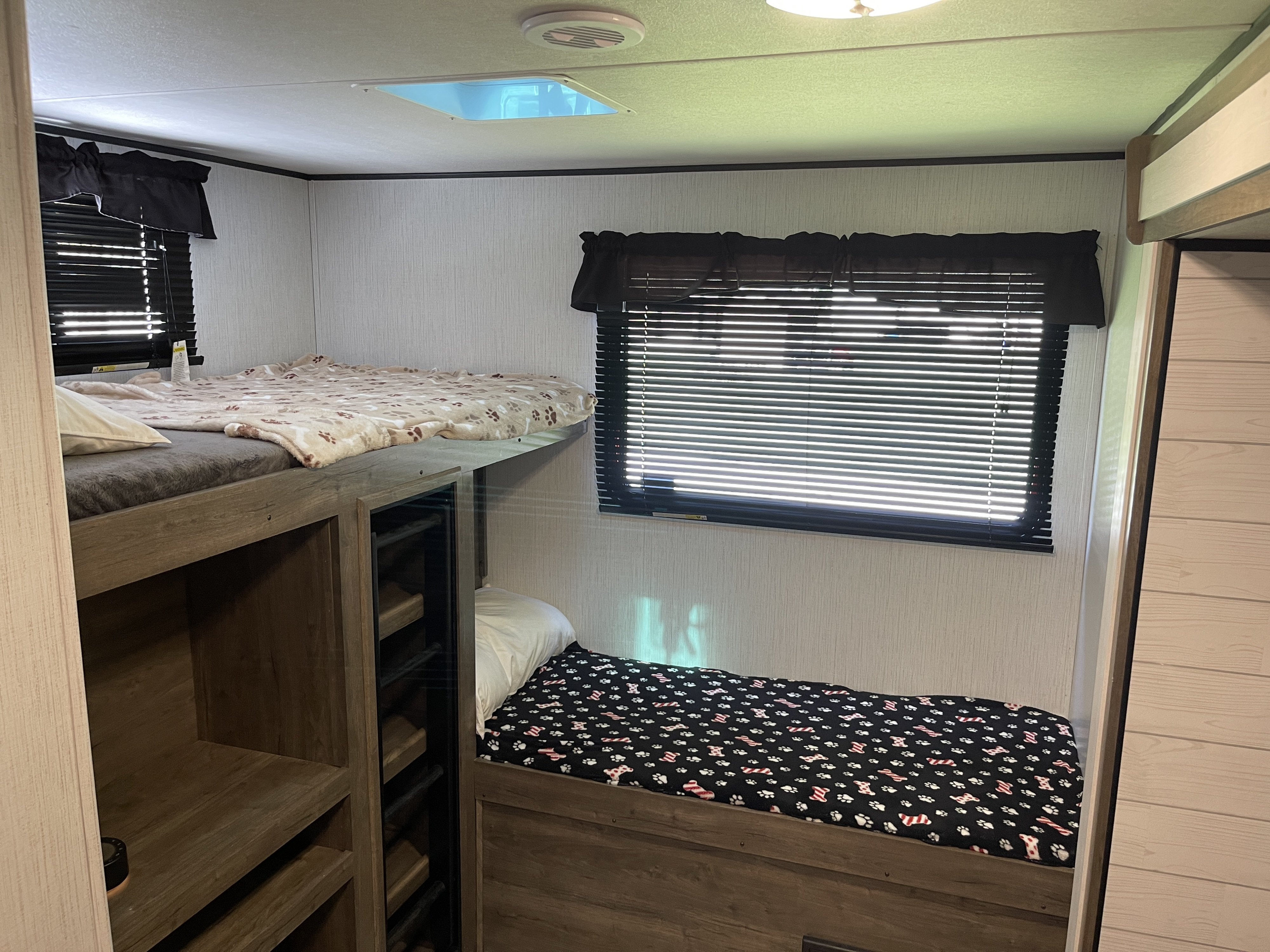 Cozy RV rental interior featuring comfortable bunk beds with playful pet-themed blankets, ideal for family adventures.. Heartland RVs Pioneer 2022