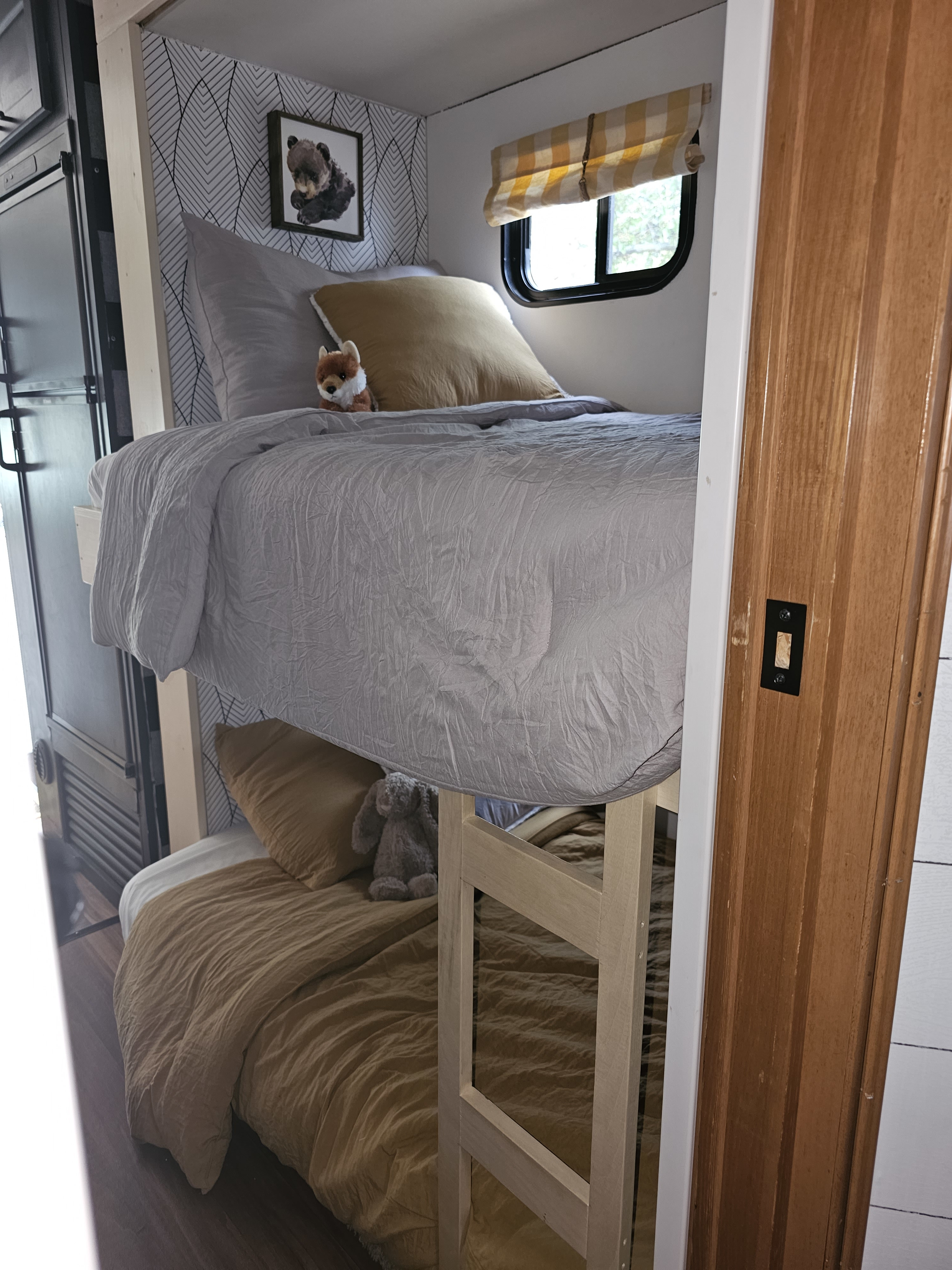 RV rental: modern bunk beds with grey & gold bedding, nature-themed decor, and compact design.. Forest River Coachmen Freelander 2014