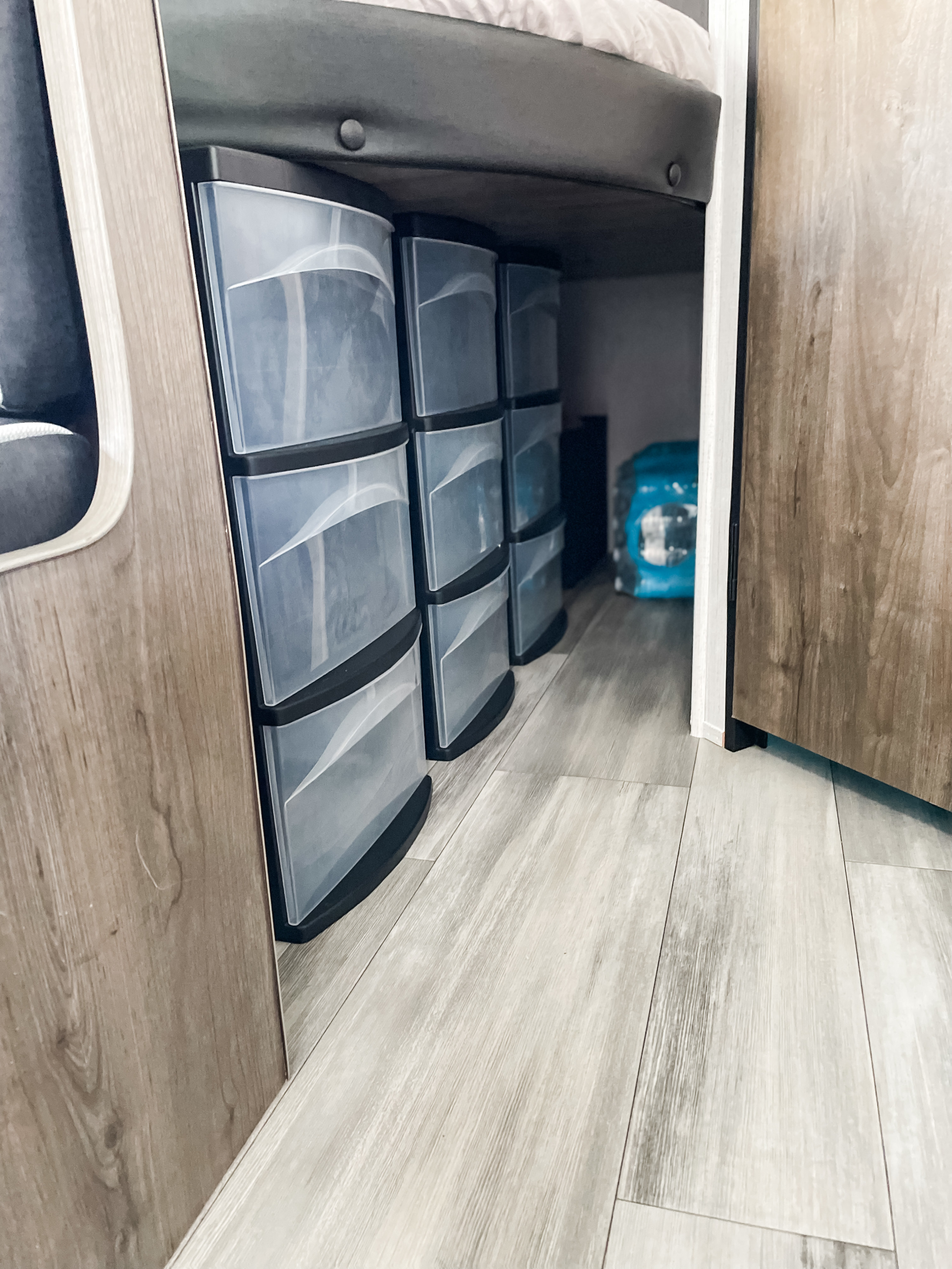 RV rental interior shows clever storage: compact, clear plastic drawer units under a bunk, ideal for organizing.. Heartland RVs Pioneer 2023