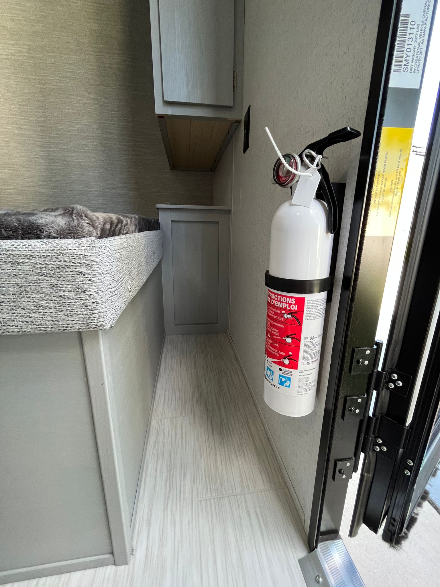 Inside an RV rental: A compact bunk bed, essential fire extinguisher, and light wood flooring in a travel trailer interior.. Forest River Cruise Lite Salem FSX 174BHLE 2023