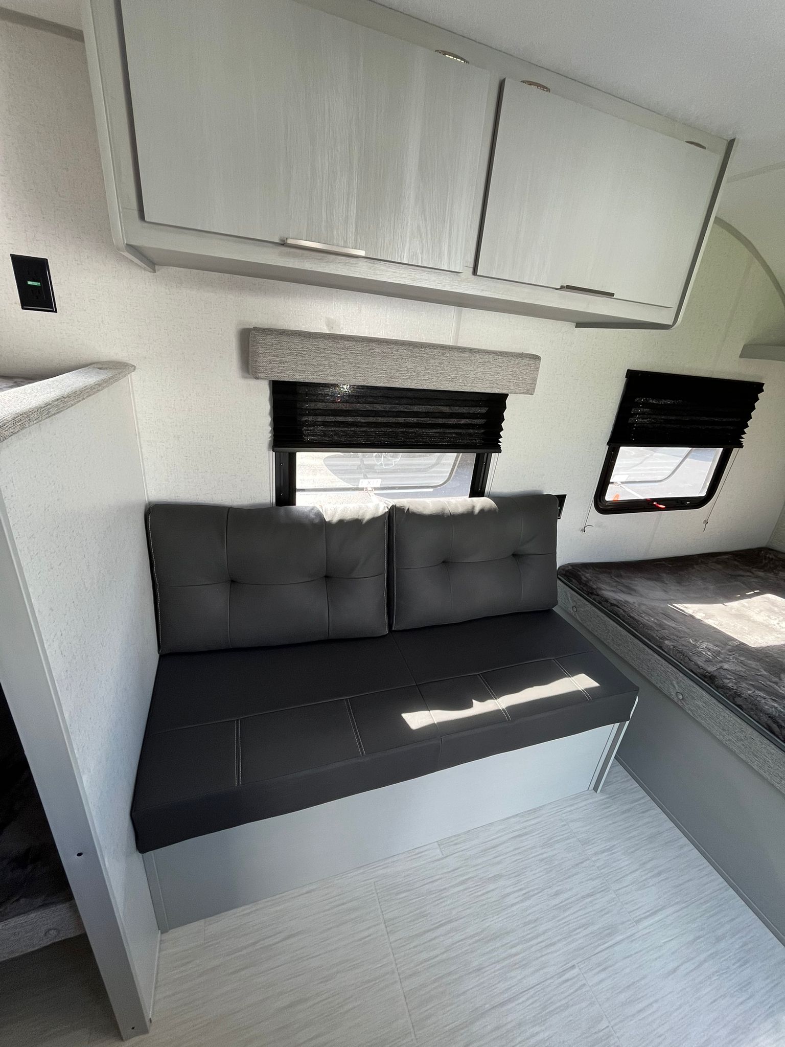 Bright RV rental interior featuring modern grey seating, bed, overhead storage, and windows.. Forest River Cruise Lite Salem FSX 174BHLE 2023
