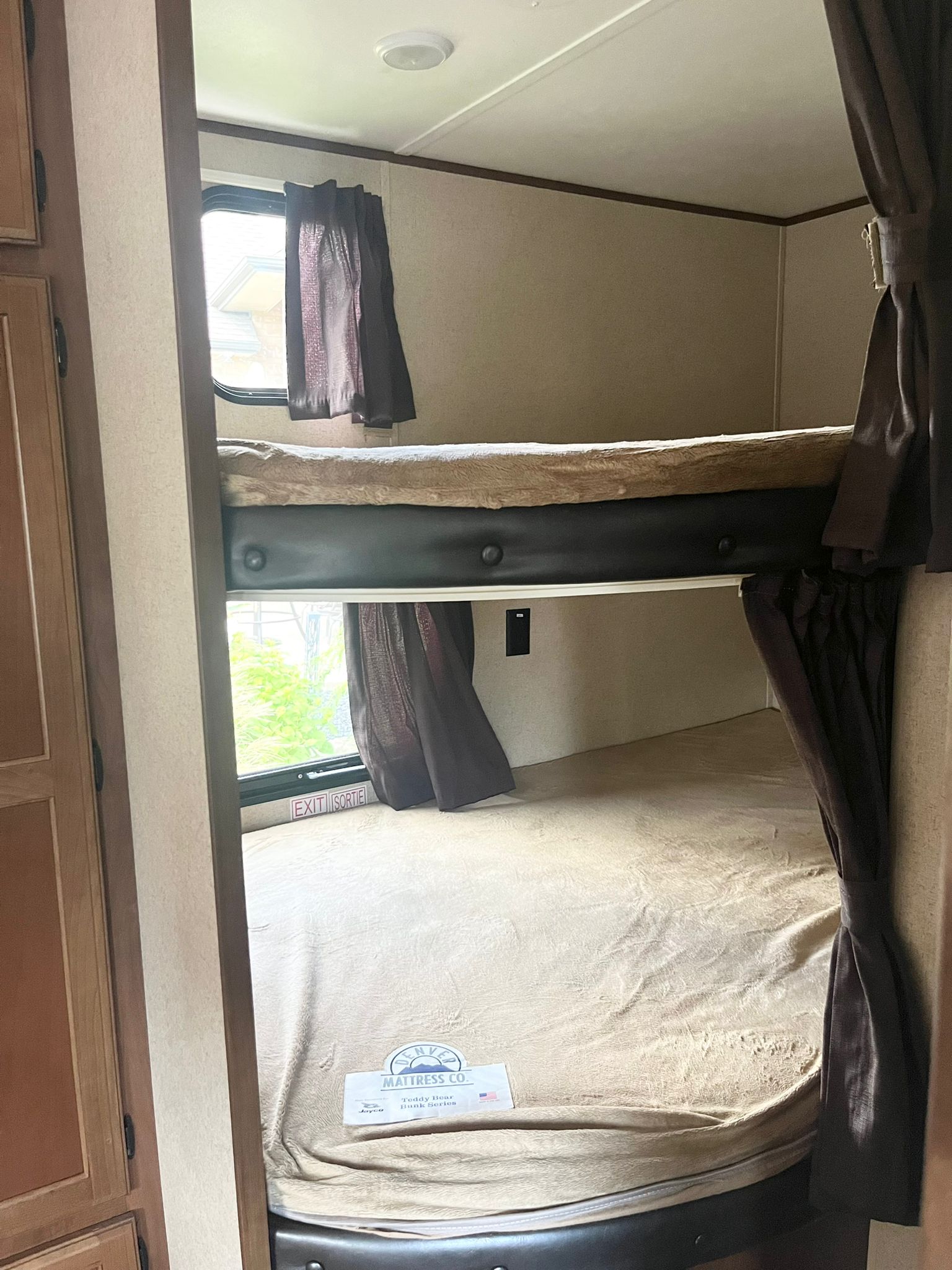 View inside an RV rental: two stacked bunk beds with windows and privacy curtains, ideal for comfortable sleeping.. Jayco Jay Flight SLX 2016