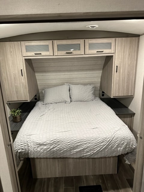 RV rental bedroom: bright, modern space with queen bed, overhead storage & side wardrobes.. Keystone RV Passport GT 2022