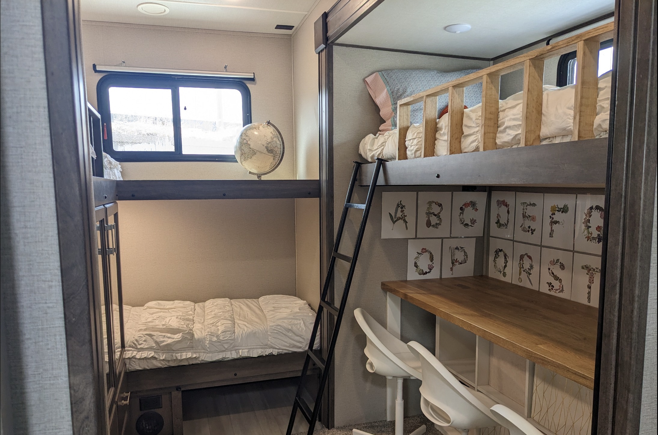Bright rv rental interior featuring multiple bunk beds, a study desk, and playful alphabet art, ideal for families.. Grand Design 3740BH 2021