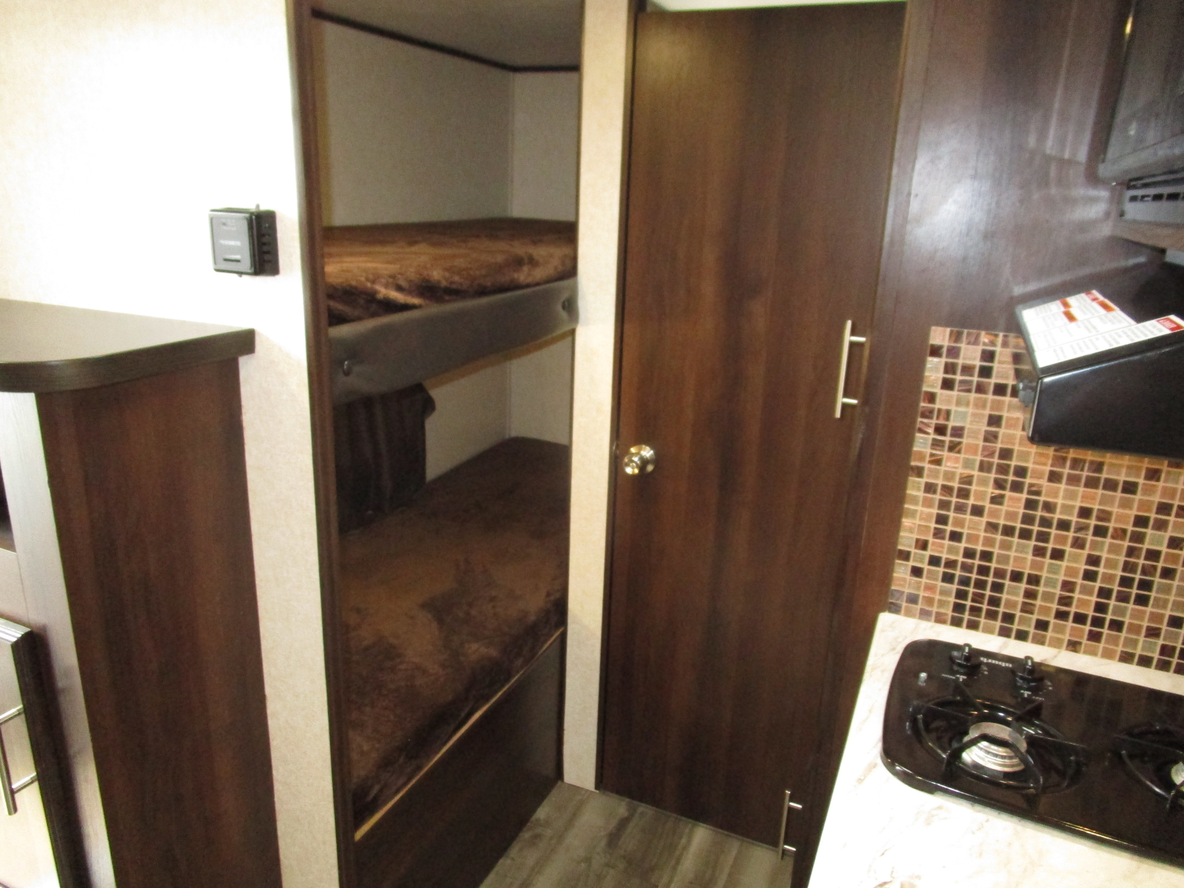 Inside this RV rental, find comfortable bunk beds, a compact kitchen with stovetop, and a convenient control panel.. Jayco 15' Baja 2019