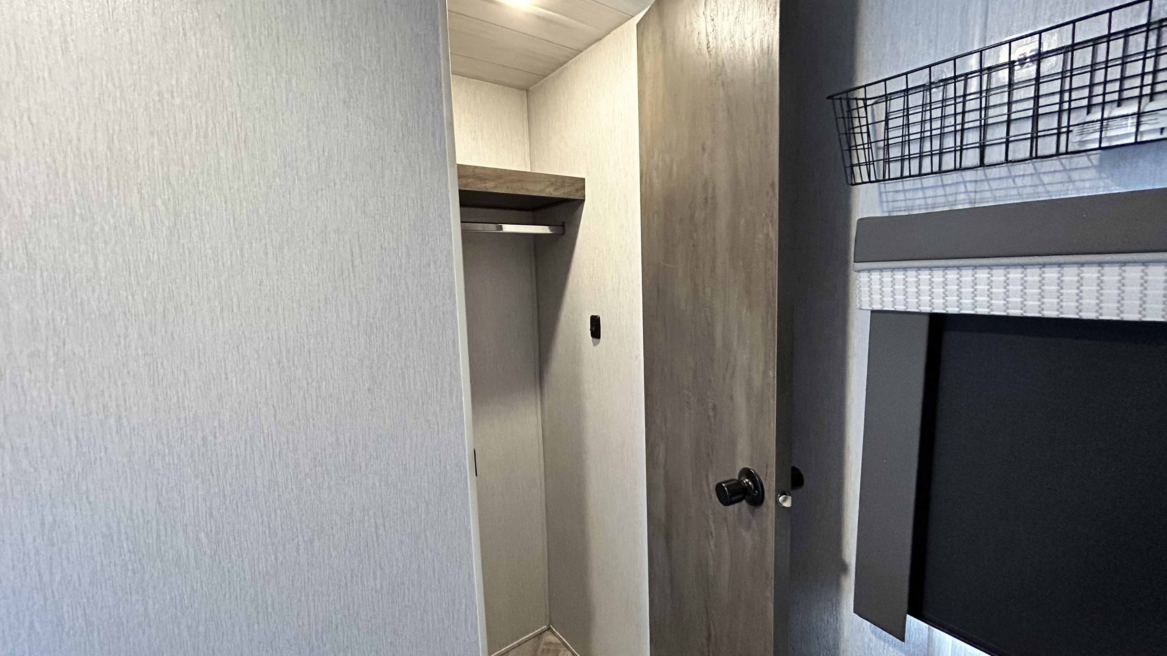 RV rental: A compact, modern interior with an open closet/wardrobe, hanging rod, and a window with a blackout blind.. Forest River Wildwood 2022