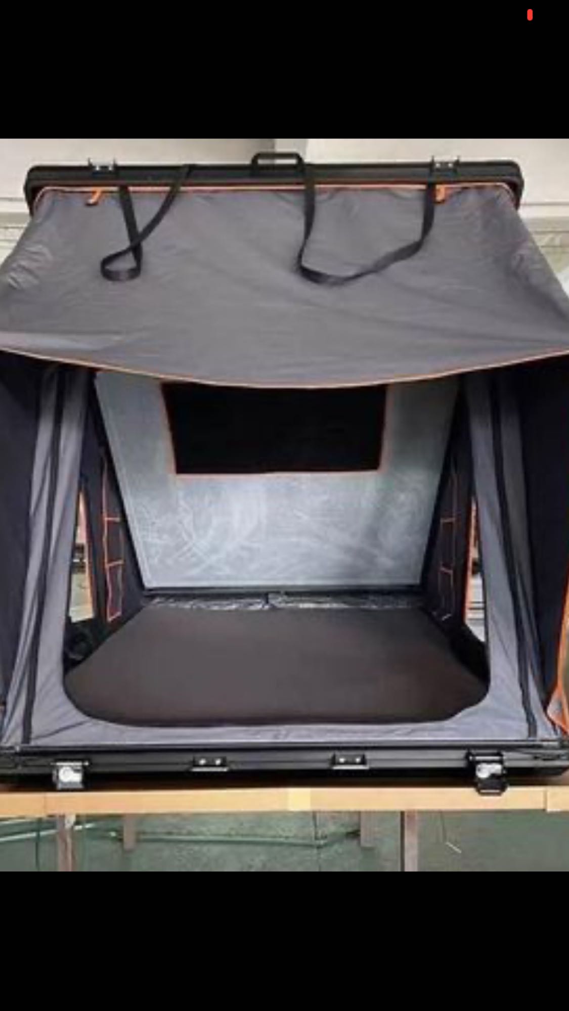 This open grey rooftop tent, ideal for RV rental adventures, offers a comfortable interior sleeping area for vehicle camping.. Toyota Other 2011