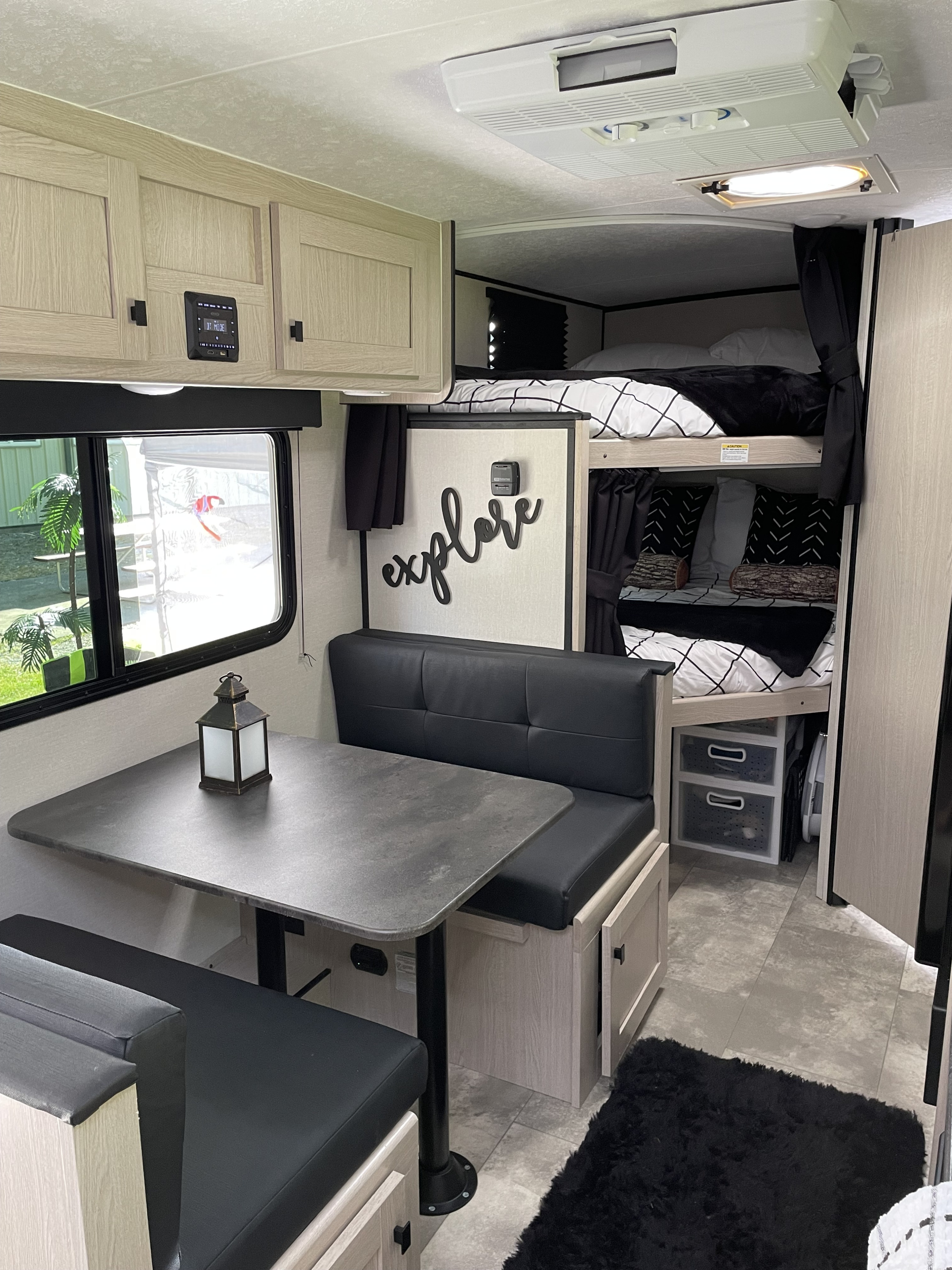 This RV rental features a cozy interior with a dinette, bunk beds, and light wood cabinetry, perfect for family travel.. Coachmen Apex Nano 2023
