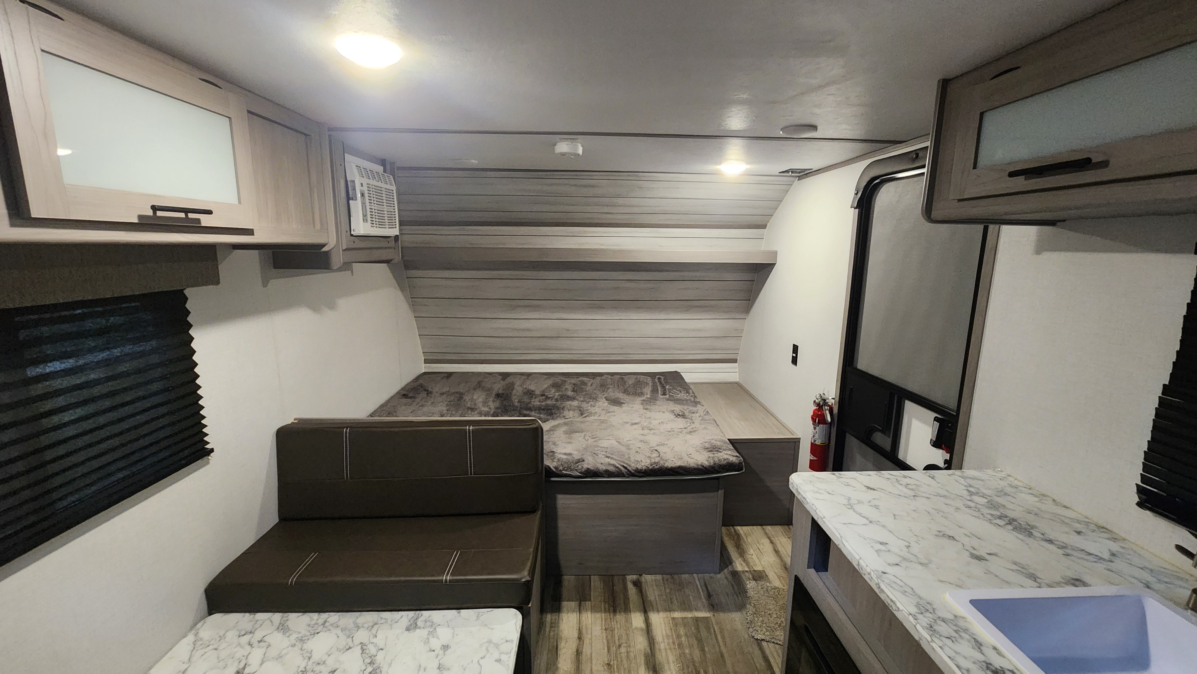 RV rental interior: a compact living space with a bed, seating, and kitchenette. Ideal for your next adventure.. Keystone RV Lantern 17B 2024