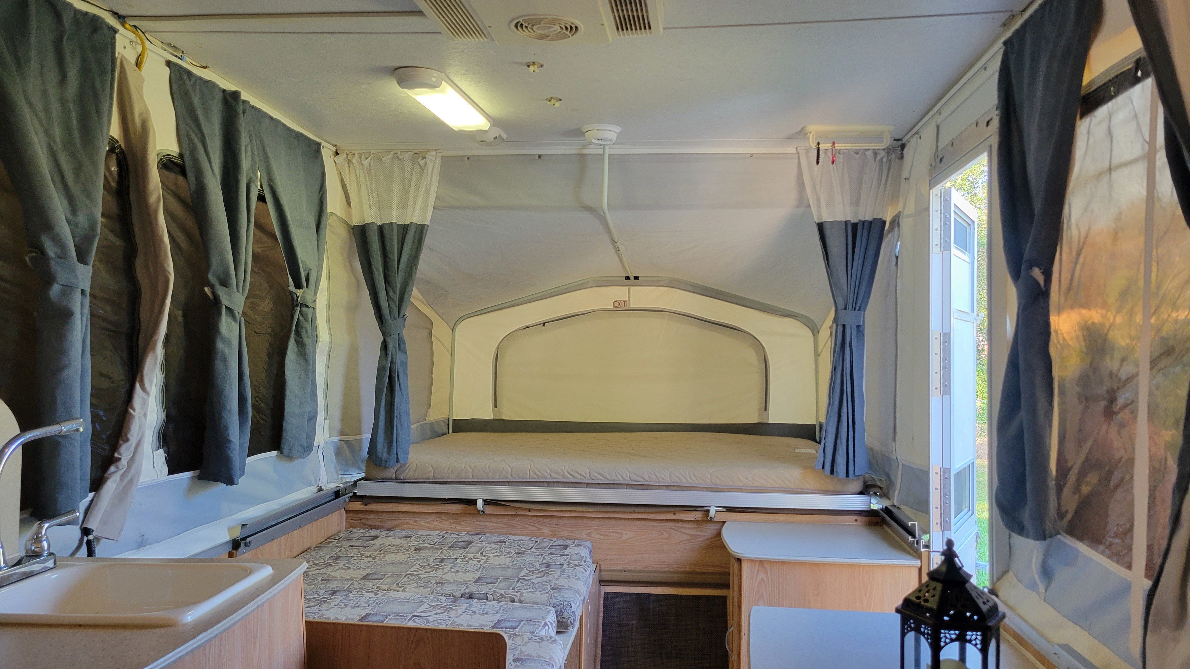 Pop-up rv rental interior: cozy living space with bed, dinette, and sink for camping comfort.. Palomino Pony pop-up 2009