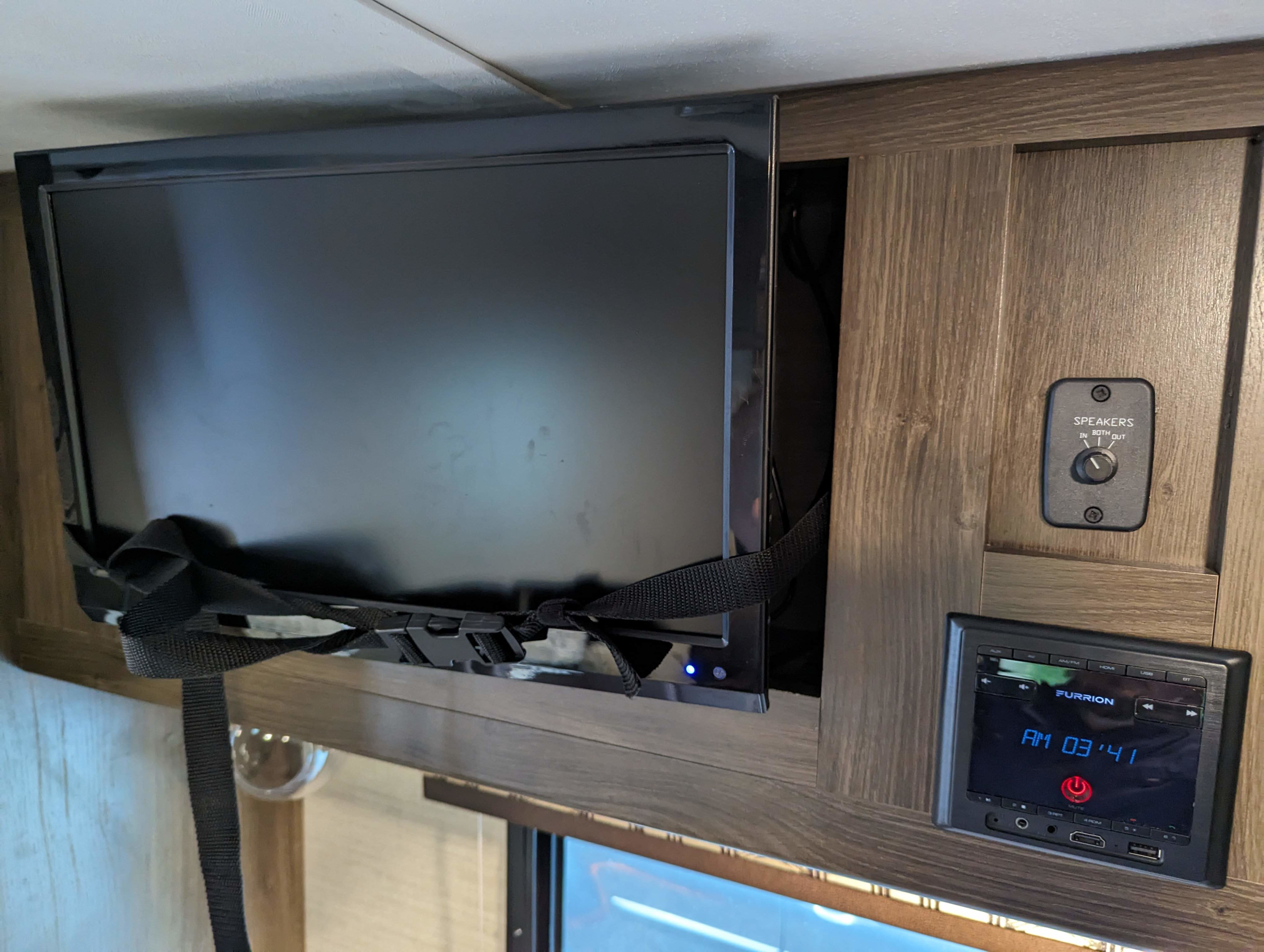 Inside an rv rental: Secured TV, Furrion multimedia system showing AM 03:41, and speaker zone controls.. Keystone RV Bullet Crossfire 2018
