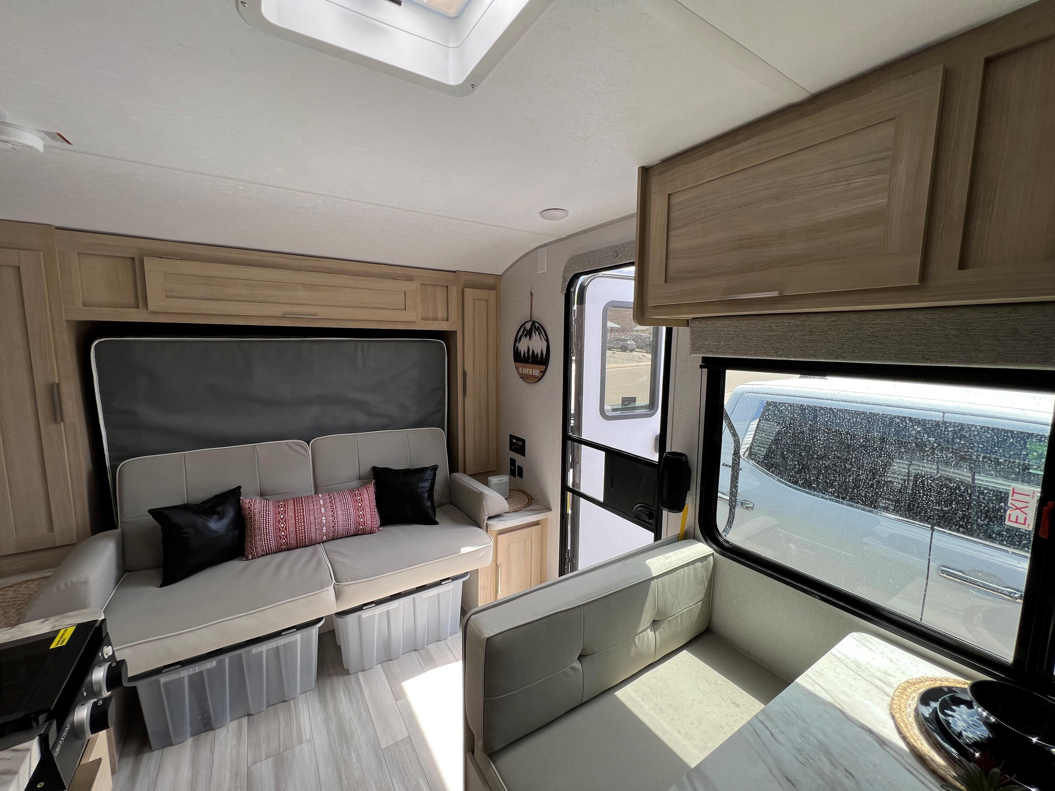 Bright, functional **rv rental** interior featuring a versatile sofa bed, under-couch storage bins, and a dining area. Ready for your trip!. Forest River Salem FSX 2023