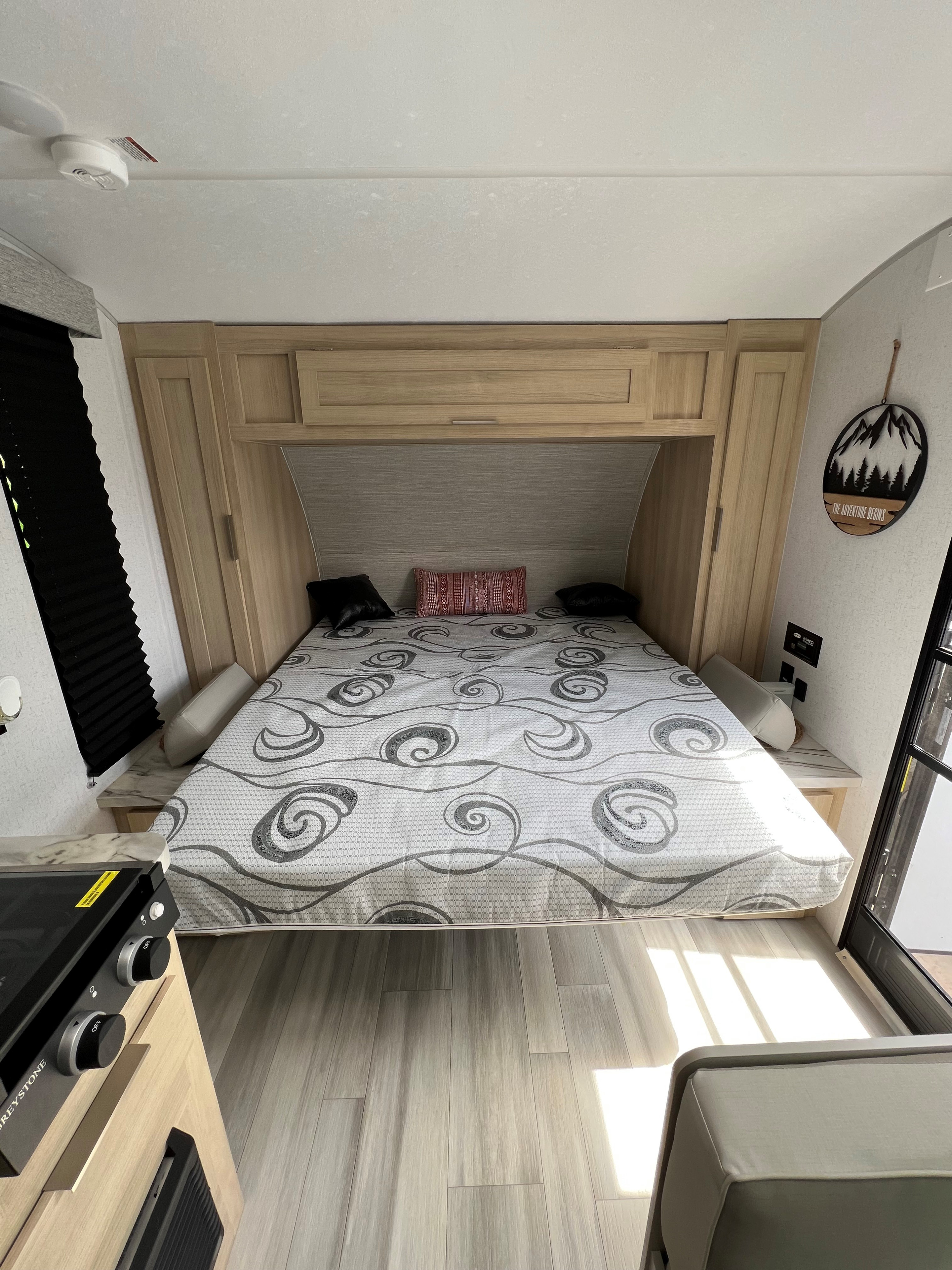 Modern RV rental bedroom interior with light wood cabinetry and a gray patterned mattress.. Forest River Salem FSX 2023