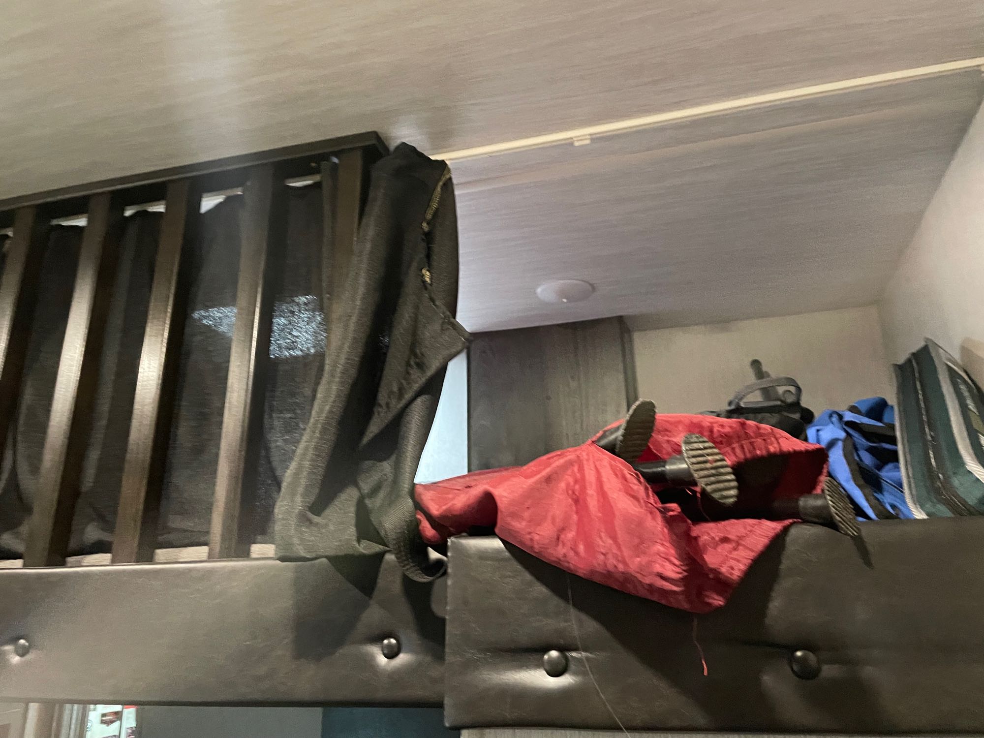 RV rental bunk bed: Interior shot shows feet in shoes, a red item, and bags on the cozy sleeping area.. Heartland Torque 2019