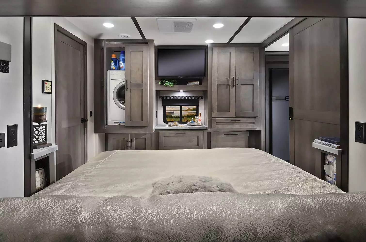 Spacious RV rental bedroom with integrated washer/dryer, TV, and ample storage, perfect for comfortable travel.. Forest River 34DS 2022