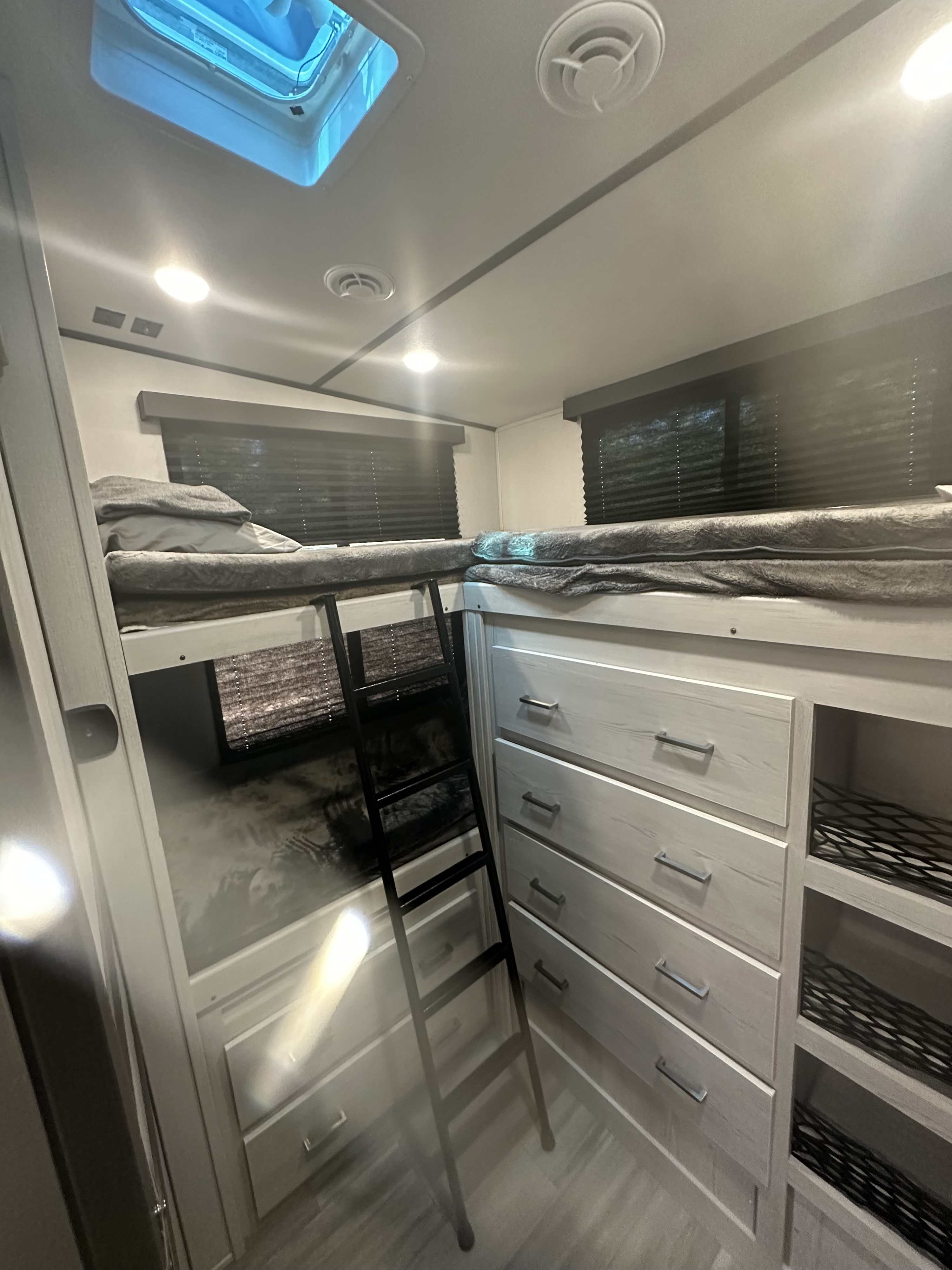 RV rental interior features bunk beds with ladder & built-in drawers and shelves, perfect for family travel.. Keystone RV Sprinter 2023