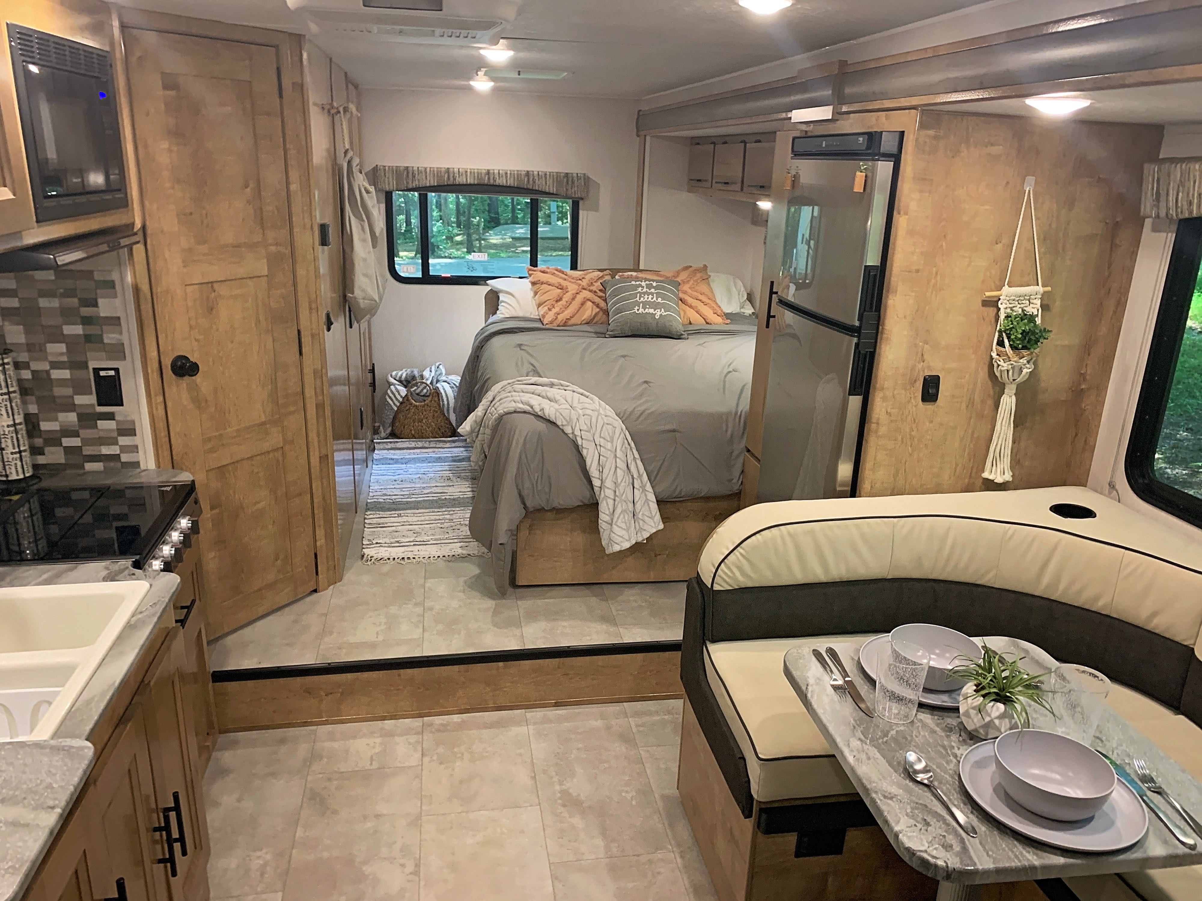 Cozy rv rental interior featuring a compact kitchen, comfortable dining booth, and a well-appointed bedroom area.. Forest River Coachmen Leprechaun 2020