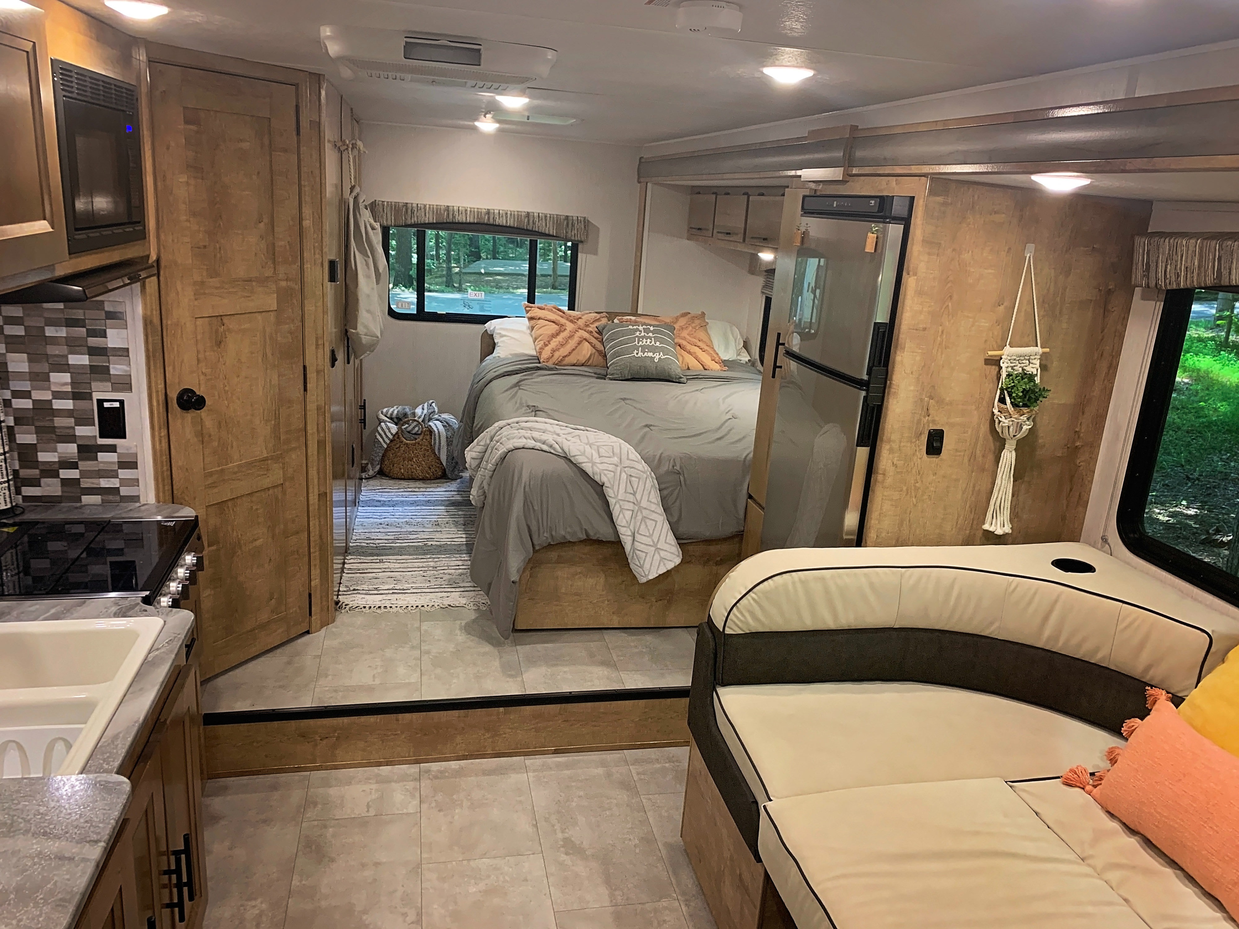 Functional RV rental interior featuring a well-appointed kitchen, inviting bedroom with window views, & comfortable living area.. Forest River Coachmen Leprechaun 2020