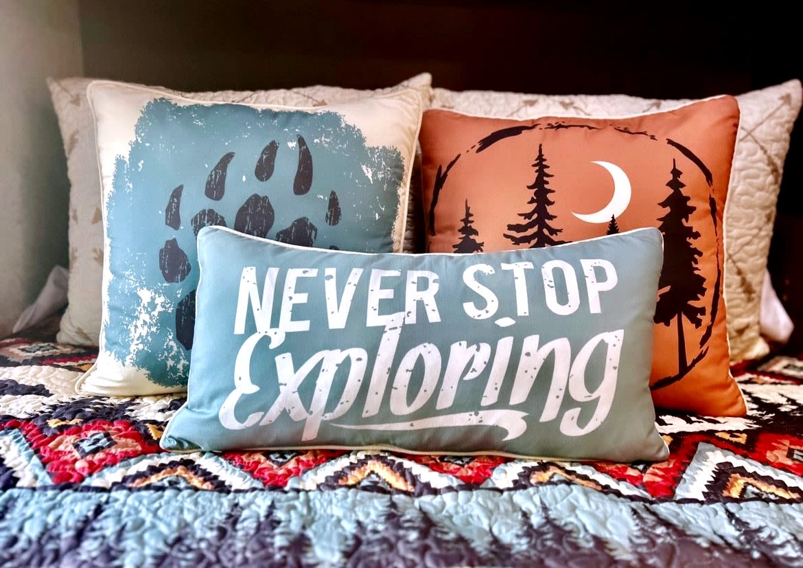 Adventure awaits in this cozy **RV rental** bed! Features "Never Stop Exploring" pillow, bear paw, & forest design.. Forest River Coachmen Prism 2018