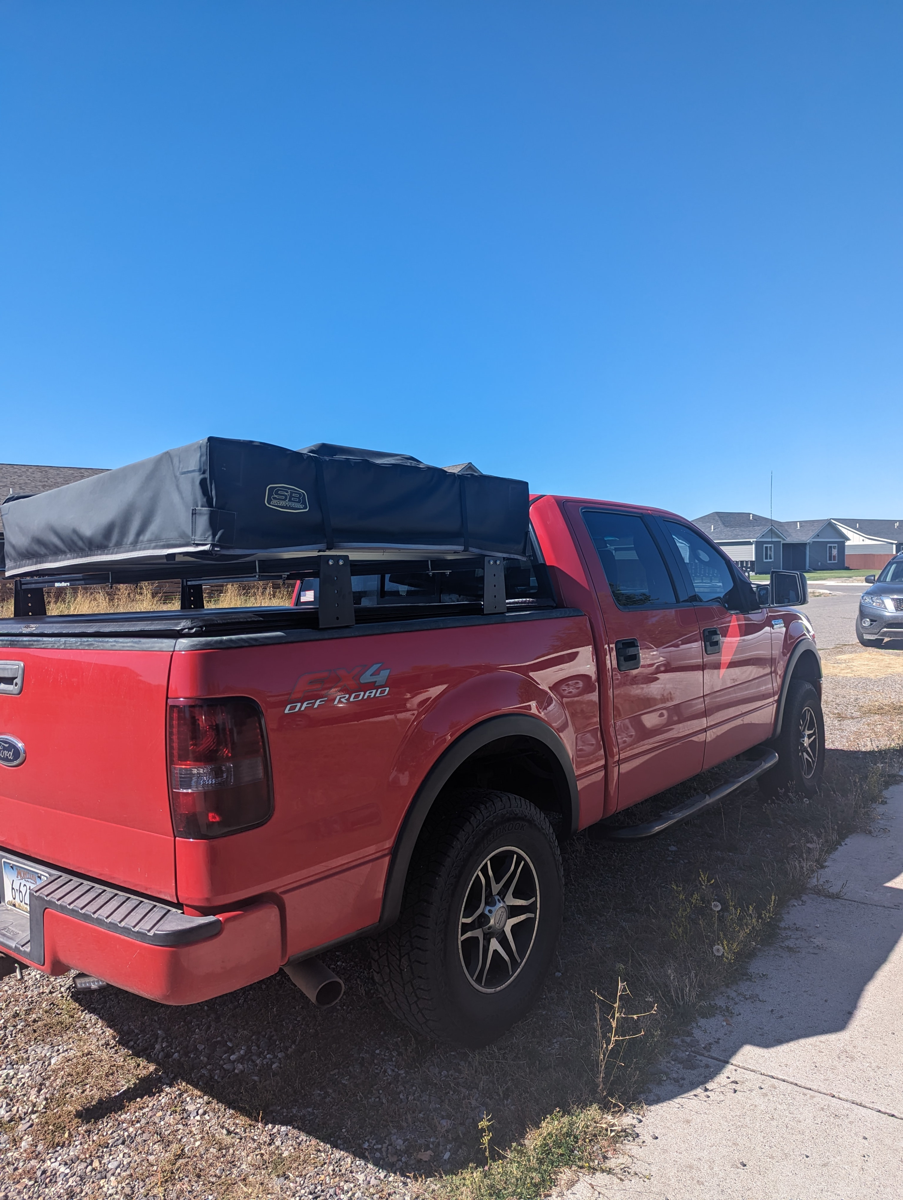 A red Ford F-150 FX4 pickup truck with a rooftop tent, offering RV rental-like convenience for outdoor camping adventures.. Ford Ford F150 2004