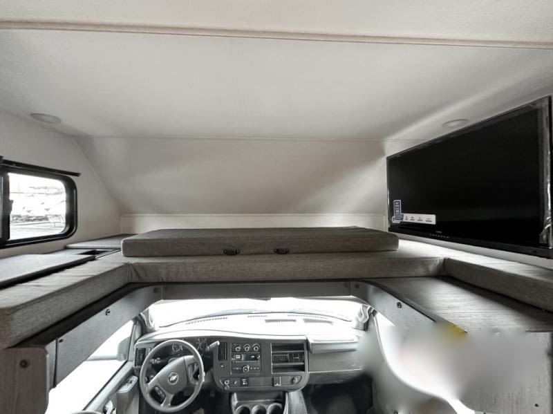 RV rental: View of the cab-over sleeping area with a bed, window, and TV, overlooking the driver's cockpit.. Forest River Sunseeker LE 2023
