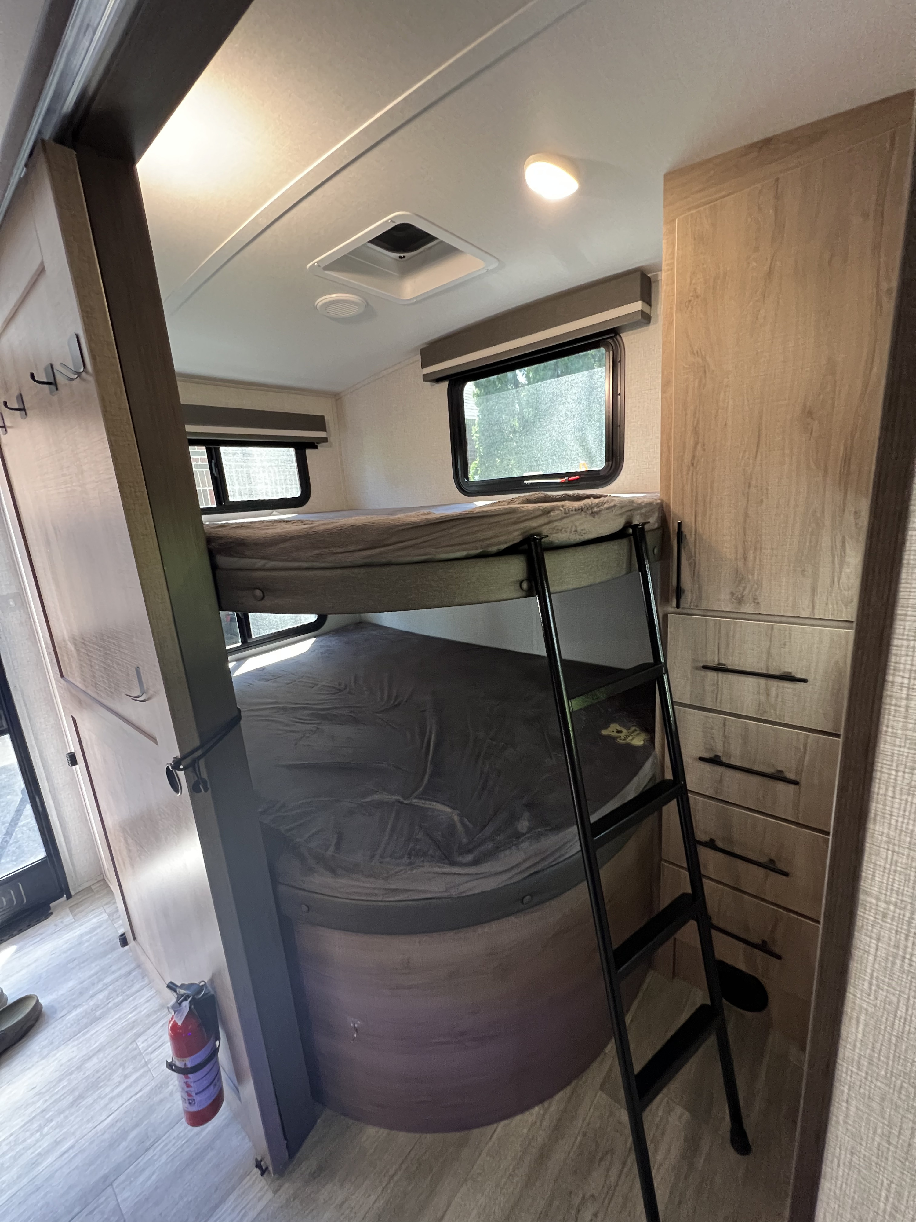 Experience this RV rental's inviting interior featuring bunk beds, a ladder, and built-in storage.. Grand Design Imagine 2023