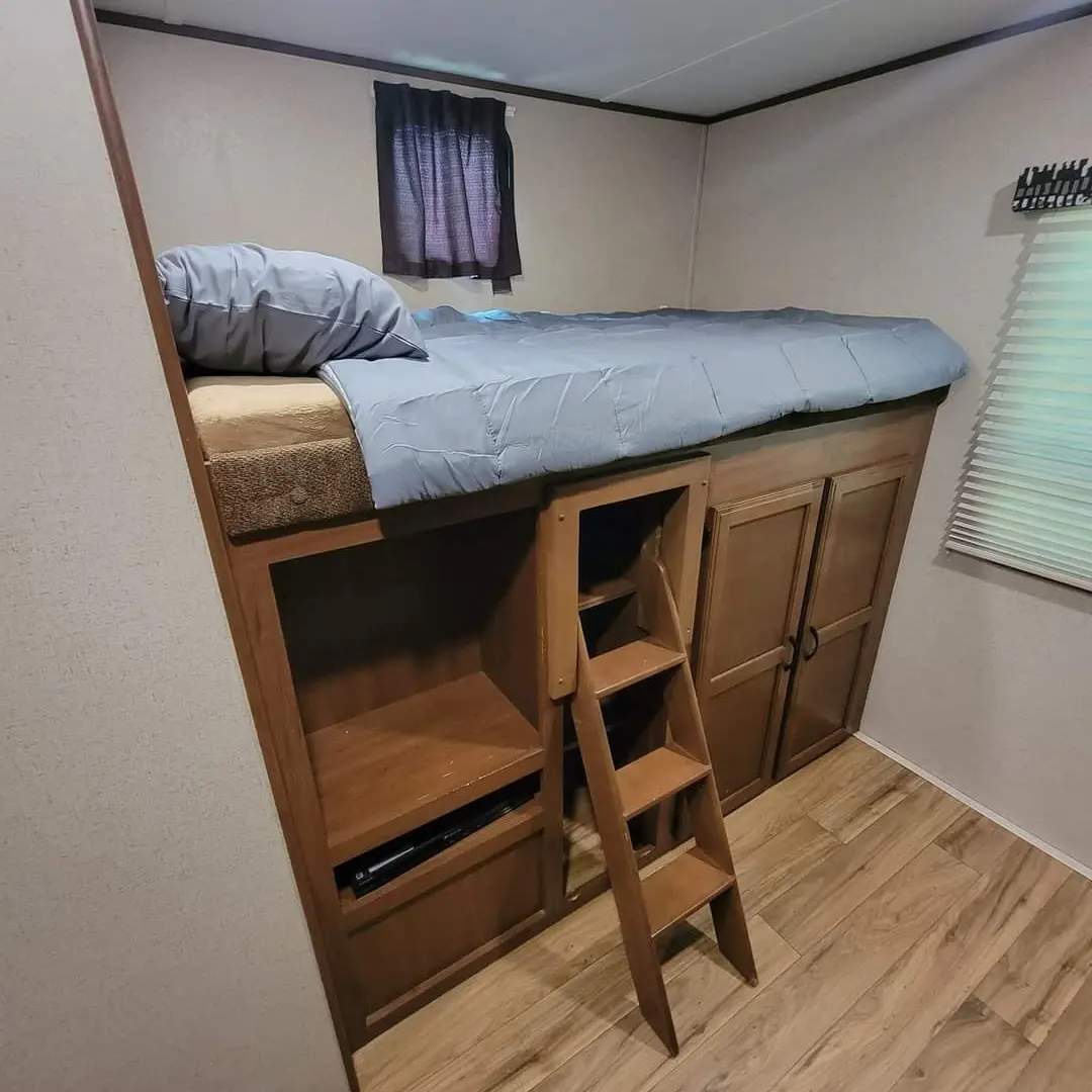 RV rental bedroom with elevated bunk bed, ladder, storage, & cabinets for travel comfort.. Jayco Jay Flight SLX 32BDSW 2016