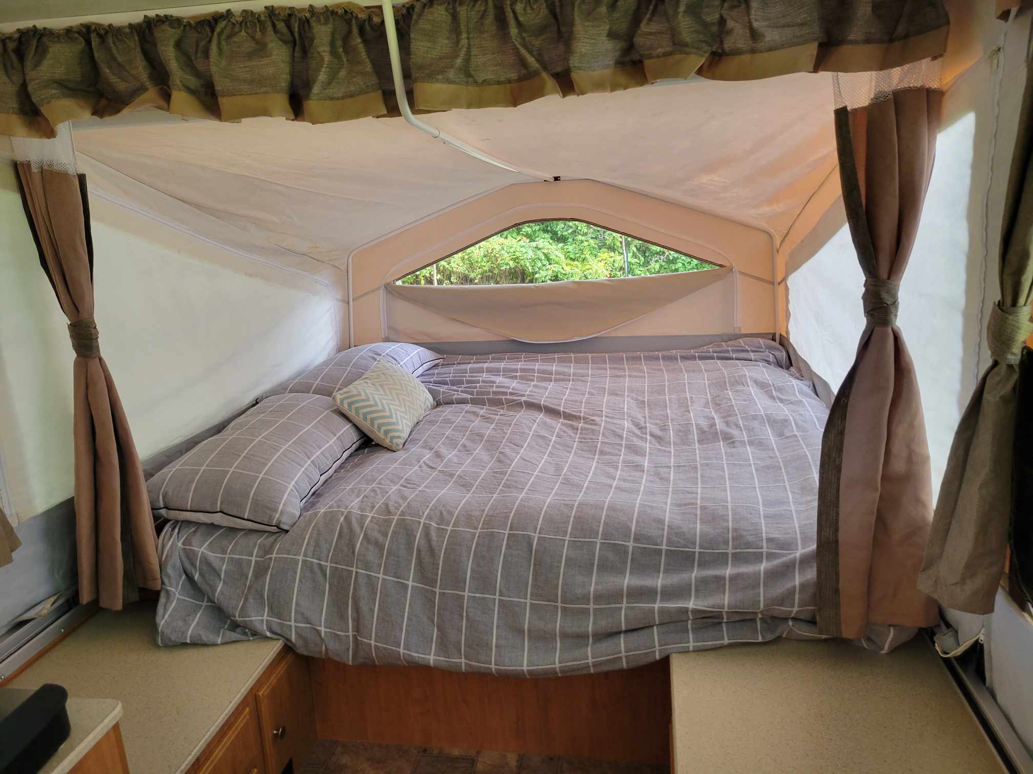 Cozy pop-up camper interior with a comfy bed & window view of nature. Ideal for your next RV rental!. Forest River Flagstaff M.A.C. 2011