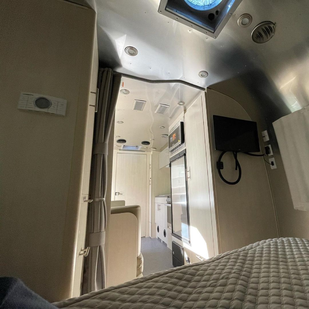 Cozy Airstream RV rental interior, showcasing bed, kitchen, and smart layout with shiny ceiling.. Airstream Flying Cloud 2021