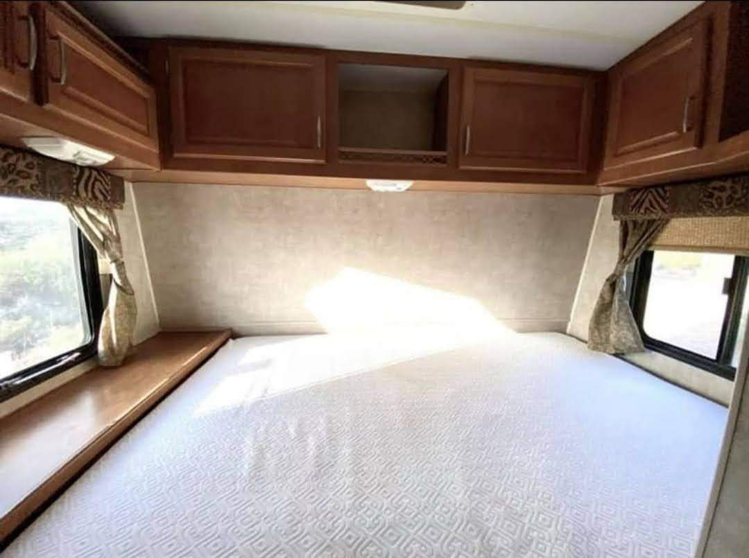 RV rental bedroom interior: spacious bed, overhead cabinets, and bright windows provide comfort for your next adventure.. Fleetwood Gearbox 2006