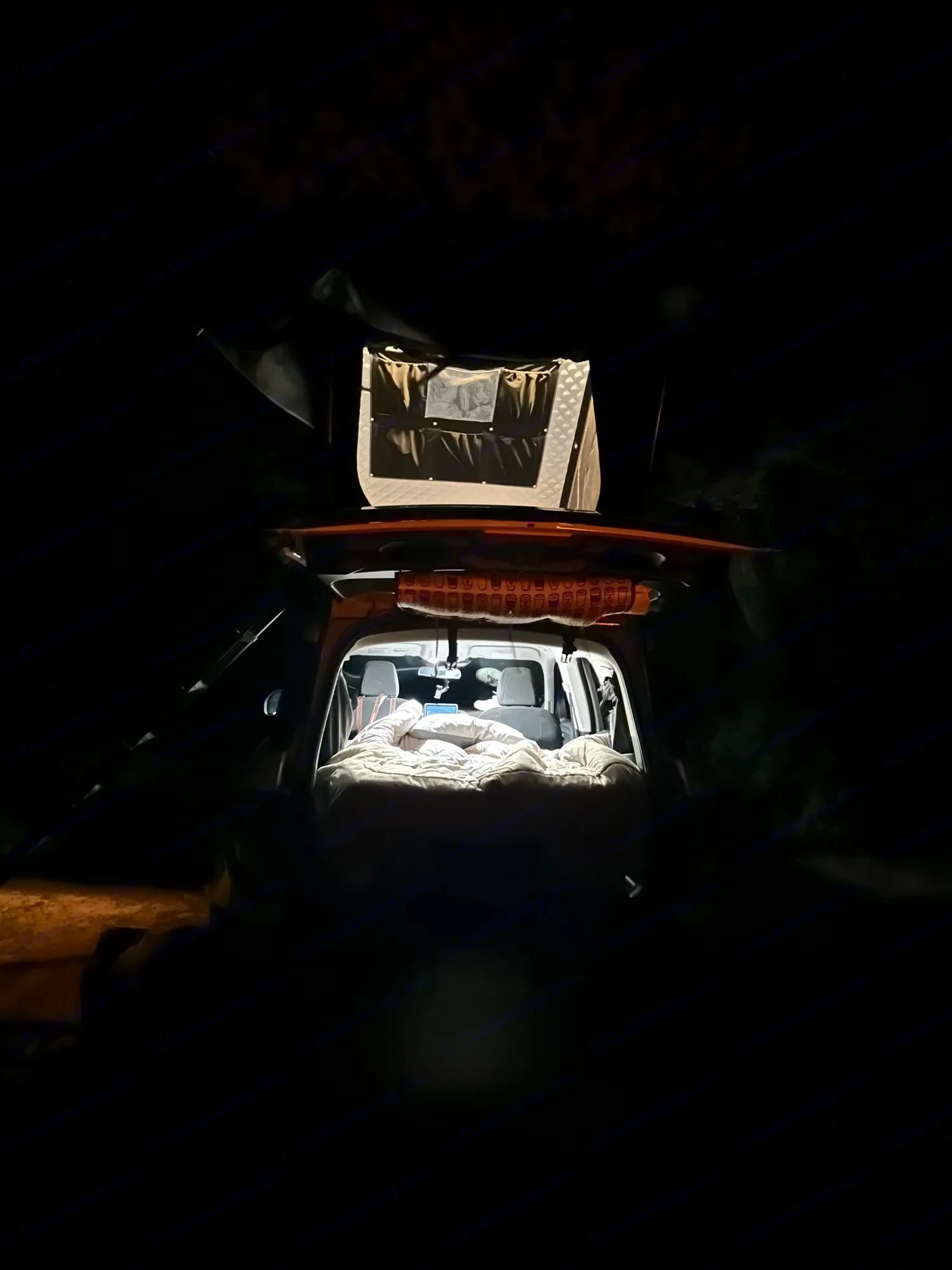 Nighttime car camping setup: SUV with interior bed & illuminated rooftop tent. Plan your next RV rental adventure!. Ford Bronco Sport 2022