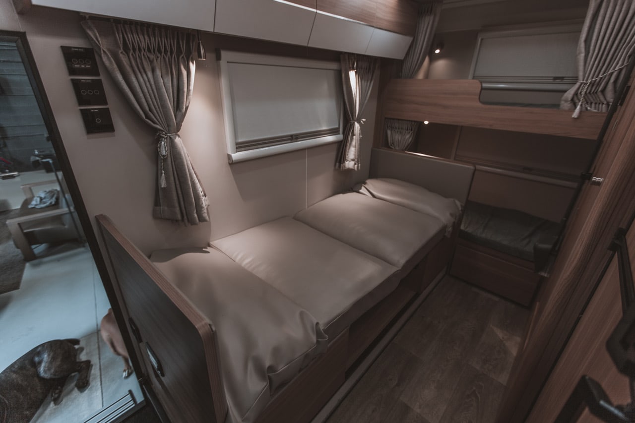 RV rental interior: practical bunk beds, a lower convertible bed, and an upper bunk. Perfect for family adventures.. Black Series Black Series Trailer 2022