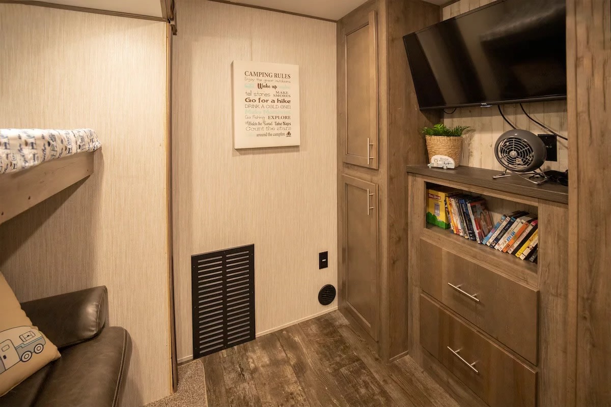 Cozy RV rental camper interior featuring bunk beds, an entertainment center, and storage. Ideal for camping trips.. Forest River Sabre 2019