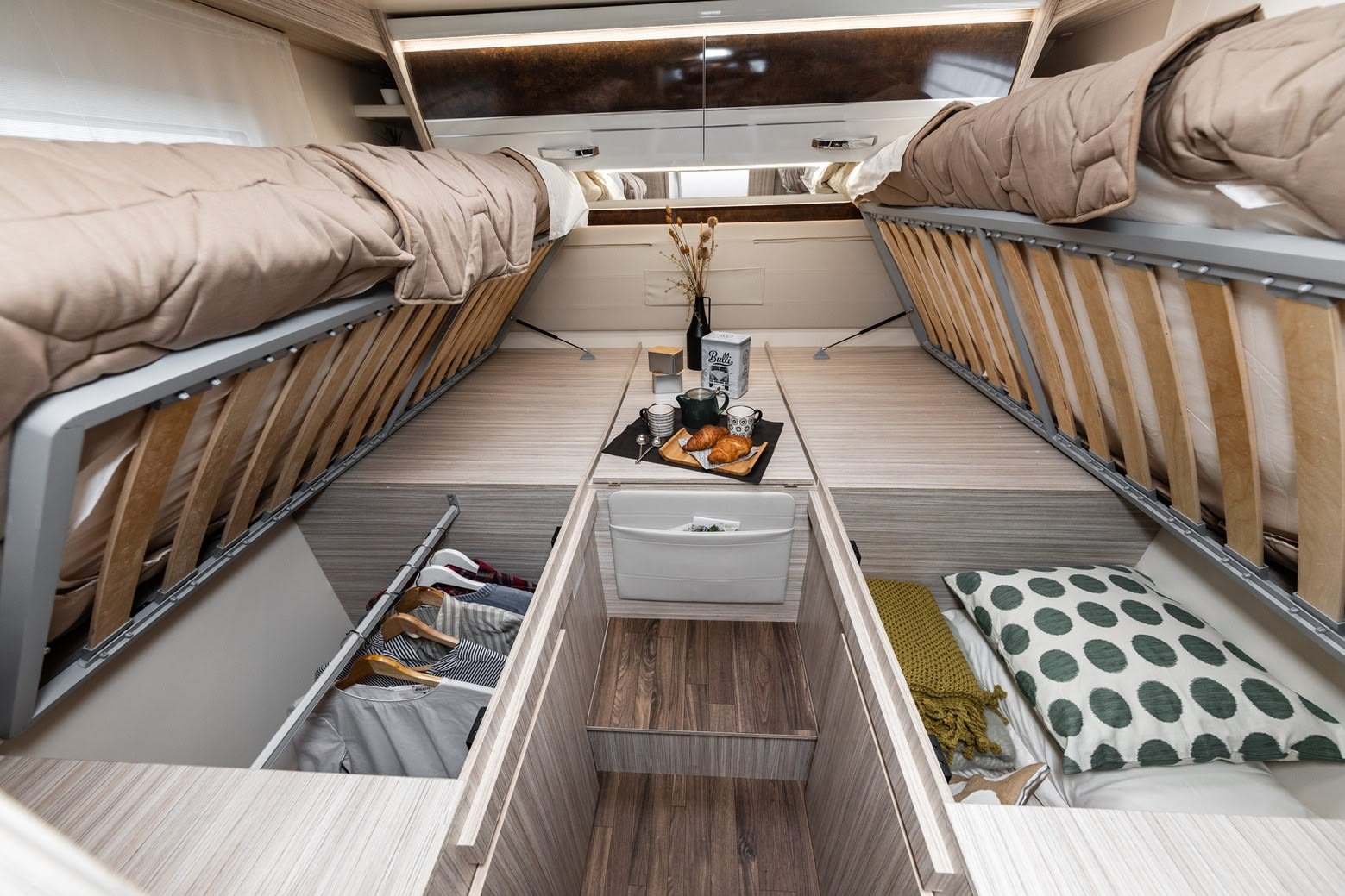 An RV rental's clever design: beds lift to reveal spacious storage for clothes & bedding, with a central aisle.. Elnagh 532 2023