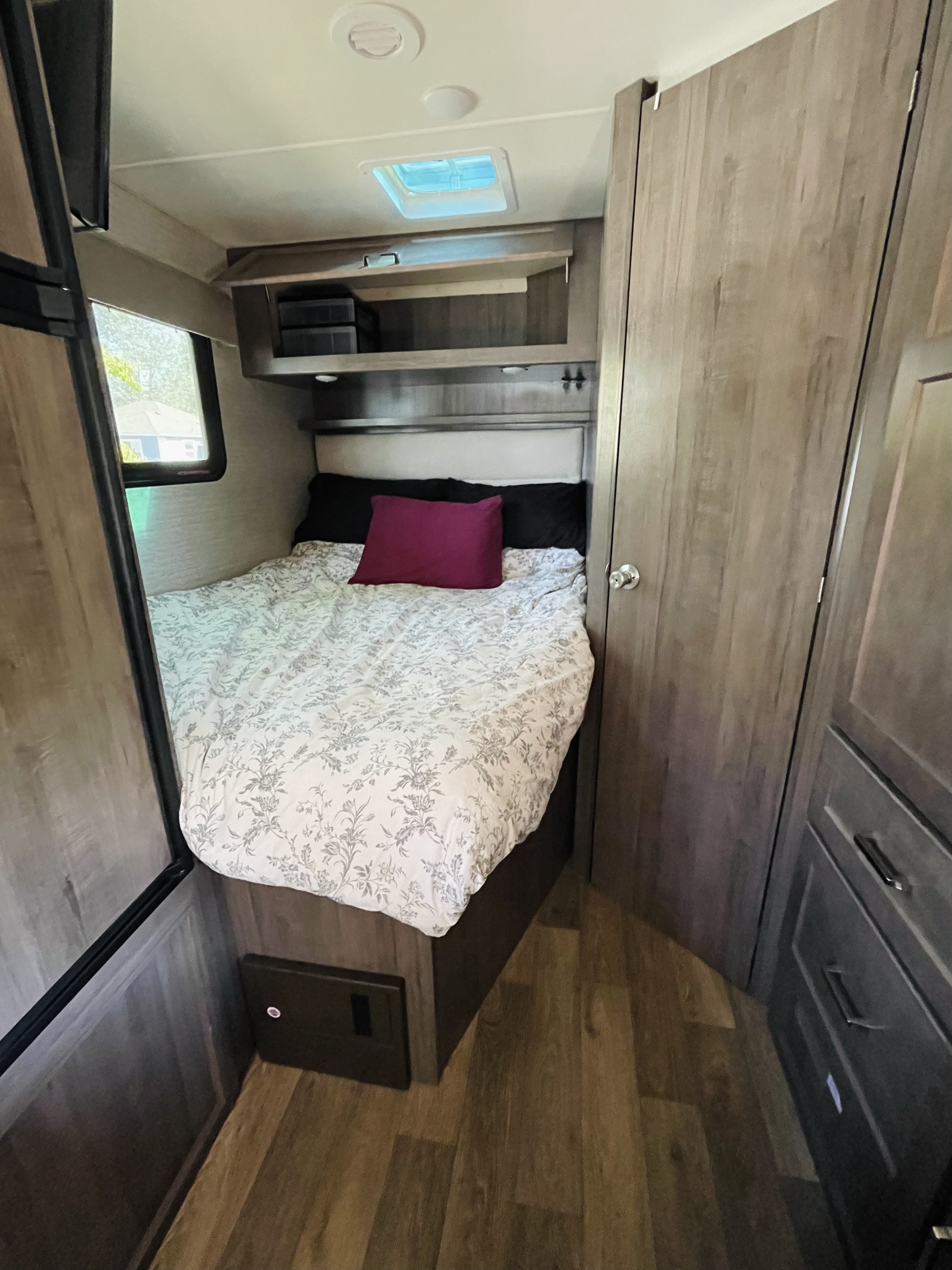 Cozy RV rental bedroom featuring a comfy bed, overhead storage, and window, ideal for travel.. Winnebago Minnie Winnie 2020